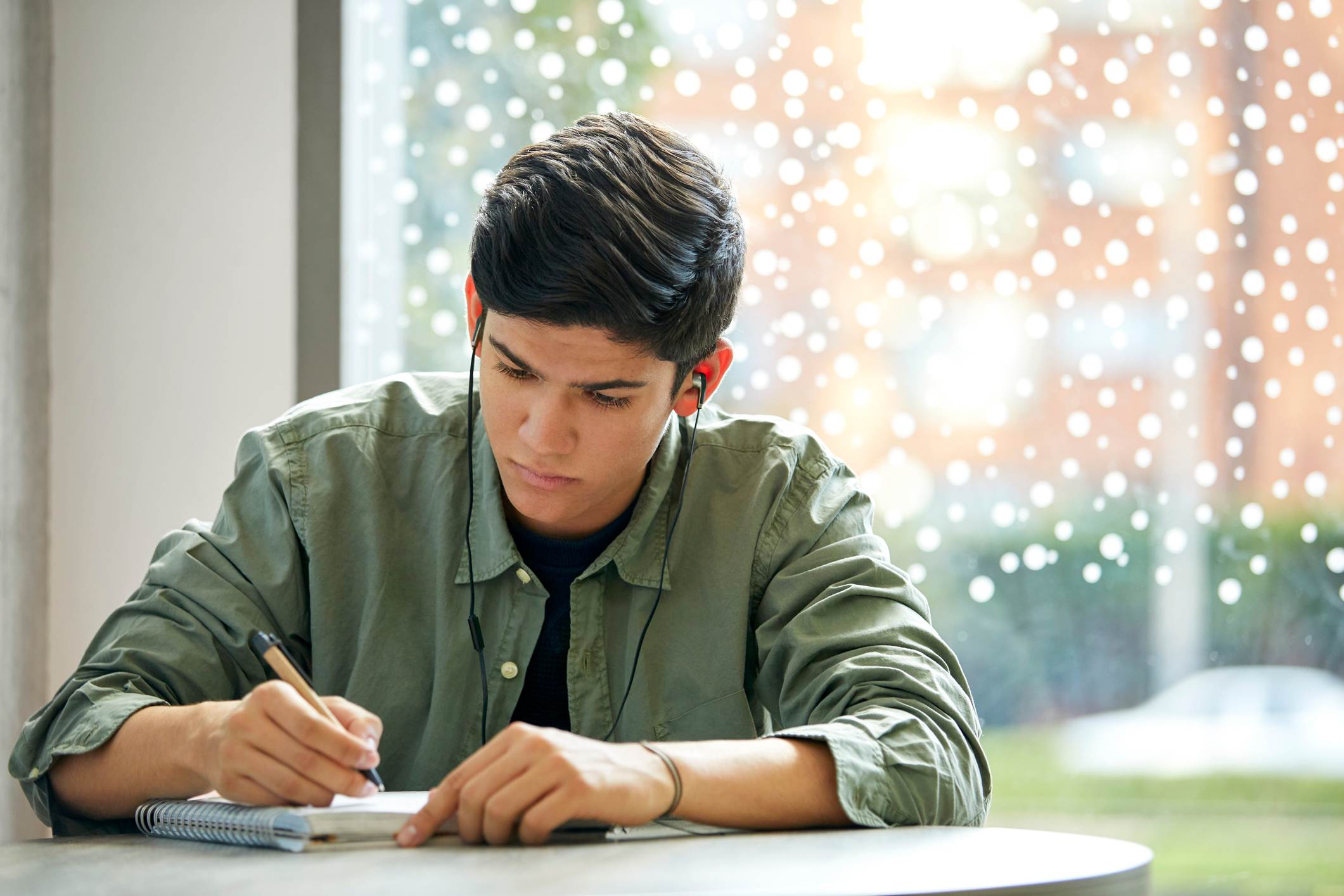 Man-sitting-alone-while-writing-on-a-notebook-how-to-be-alone-with-my-thoughts