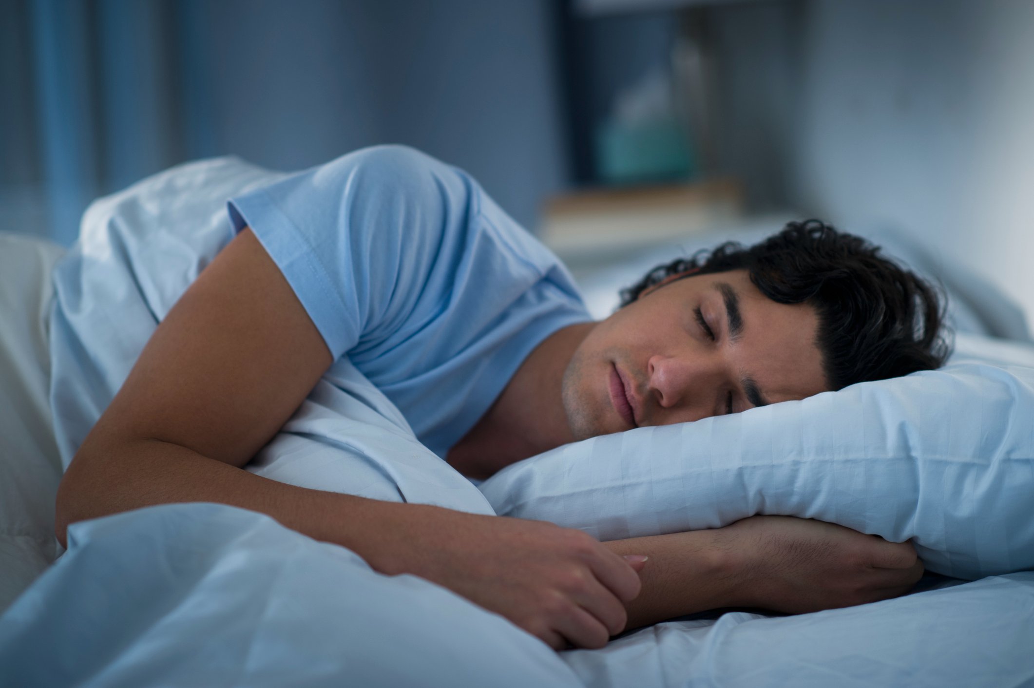 Man-sleeping-in-bed-how-to-sleep-earlier