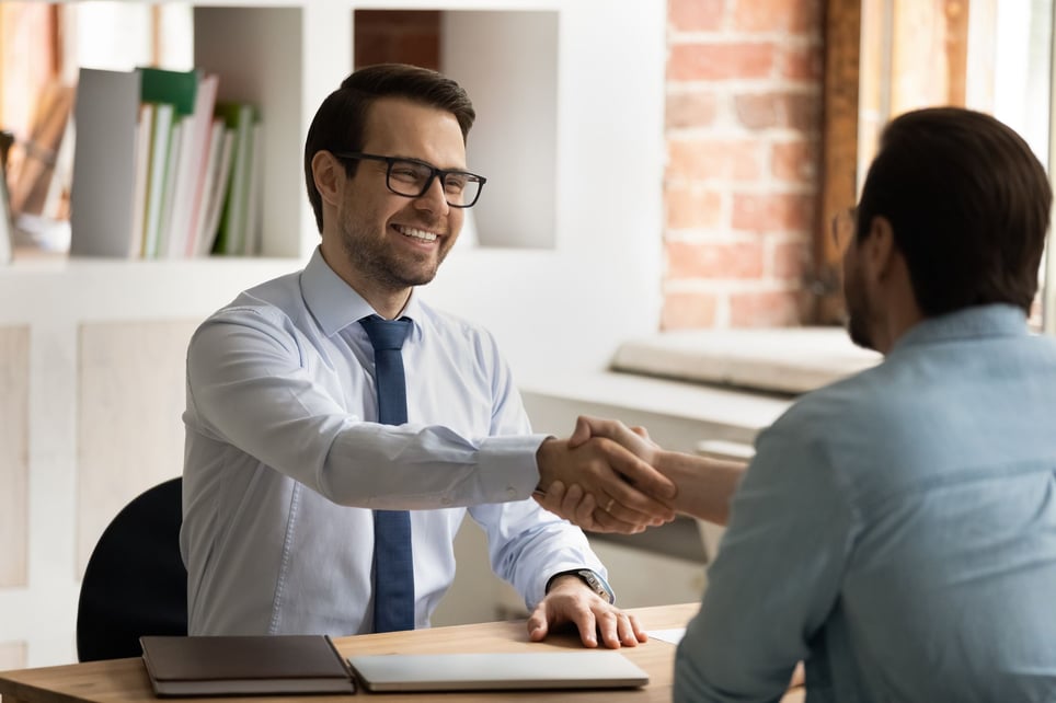 Man-smiling-giving-firm-handshake-at-job-interview-second-interview-questions