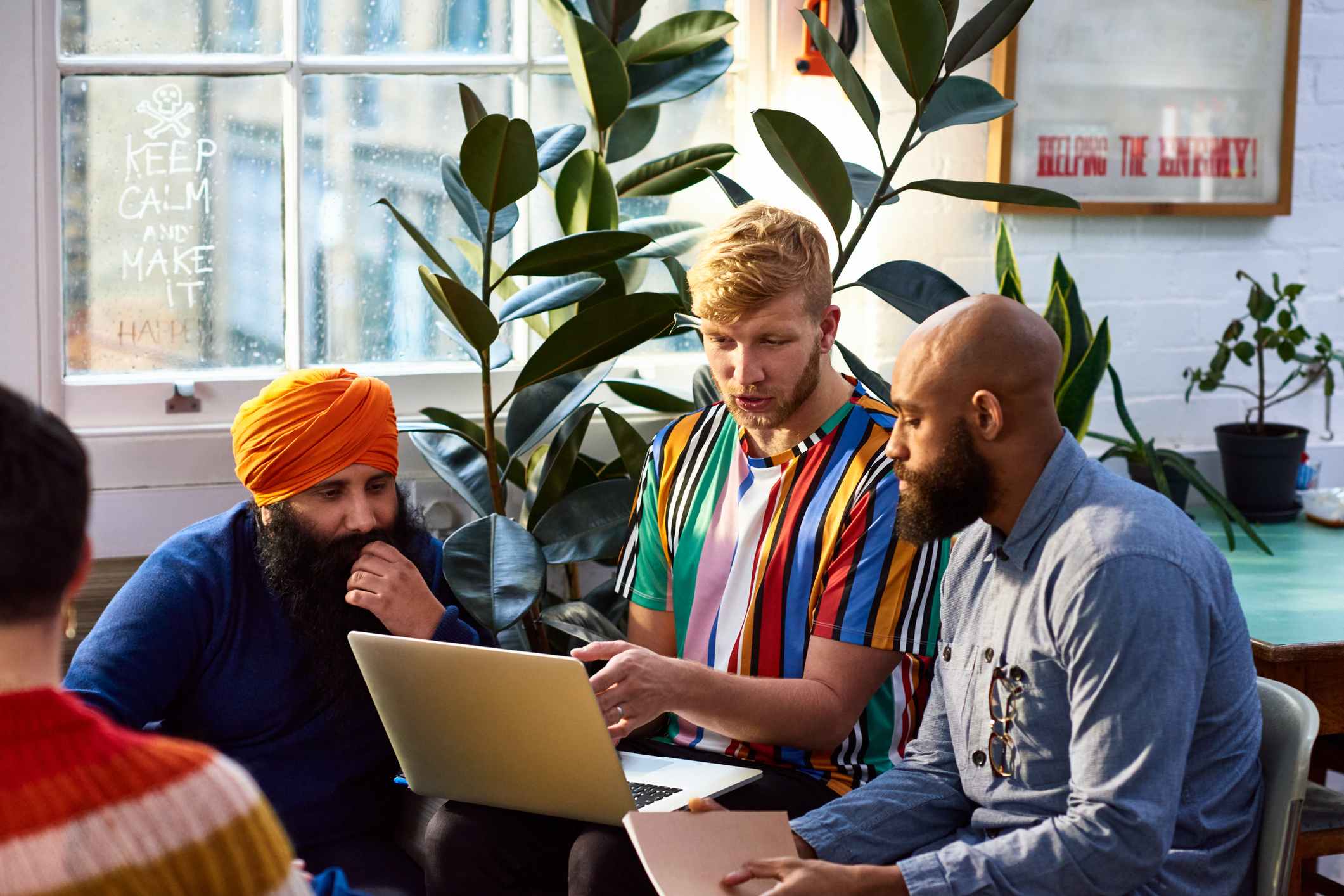 Man-using-laptop-with-multi-racial-colleagues-active-listening