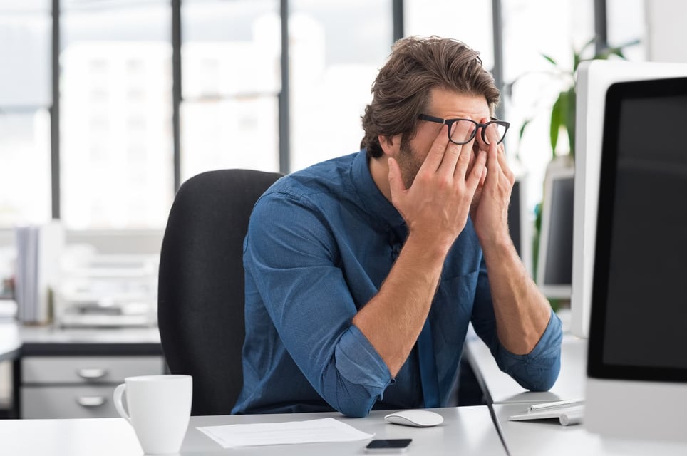 Man-with-hands-on-his-eyes-looking-angy-at-the-office-how-to-deal-with-rejection