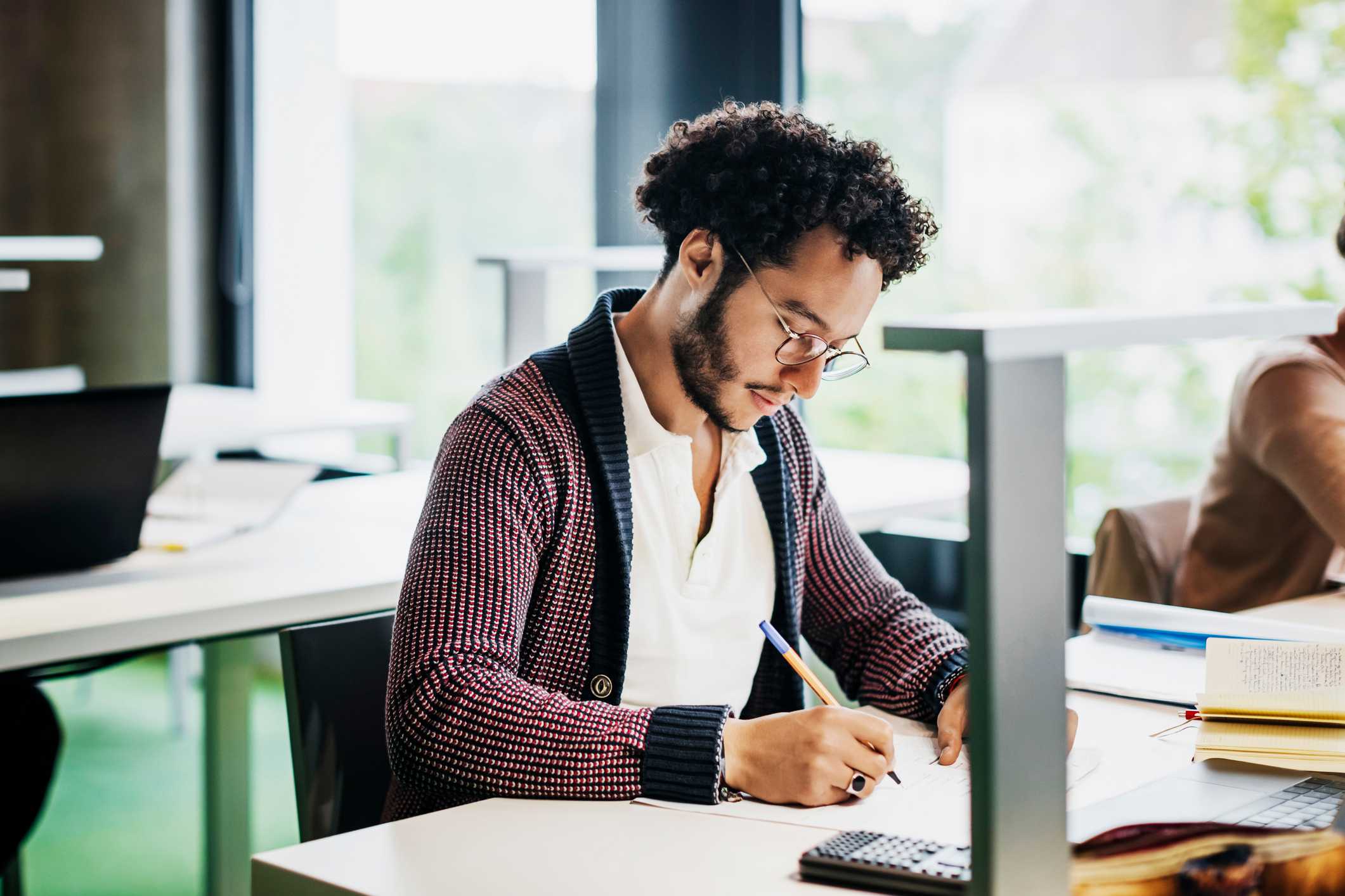 Man-writing-on-notebook-at-office-what-is-lateral-thinking