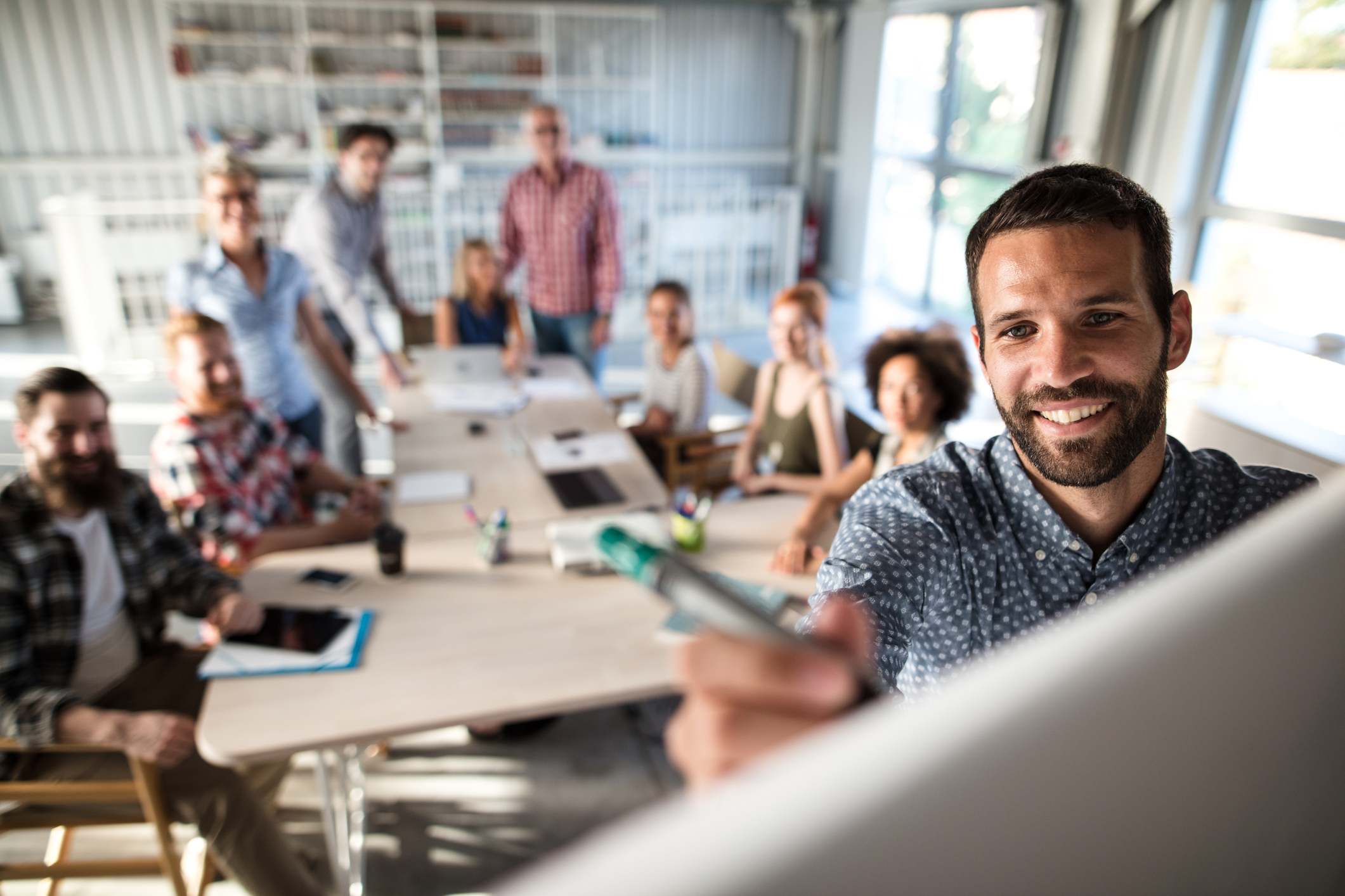 Man-writing-something-on-white-board-in-front-of-work-team-decision-making-style