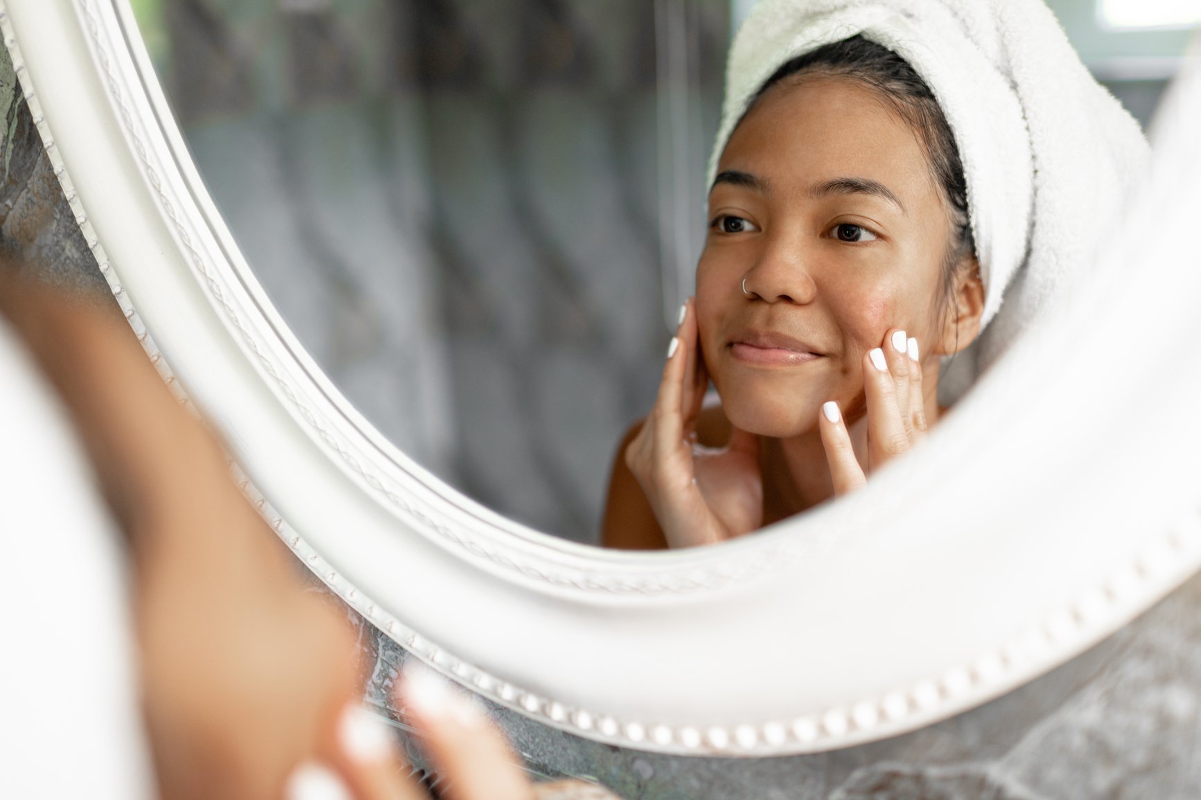 Mirror-reflection-of-a-smiling-young-lady-wrapped-in-white-towel-how-to-overcome-insecurities