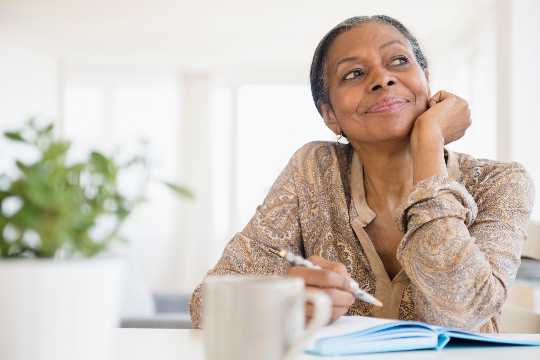 Mixed-race-woman-journaling-at-desk-how-to-start-over-in-life-at-50