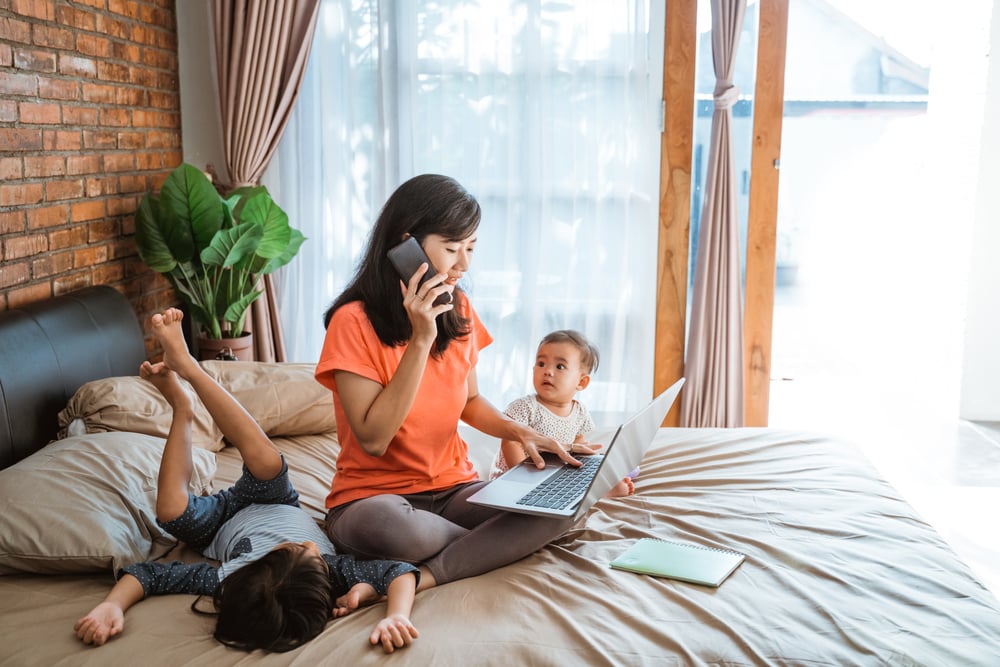 Mom-working-from-bed-with-her-two-children-how-to-be-a-working-mom