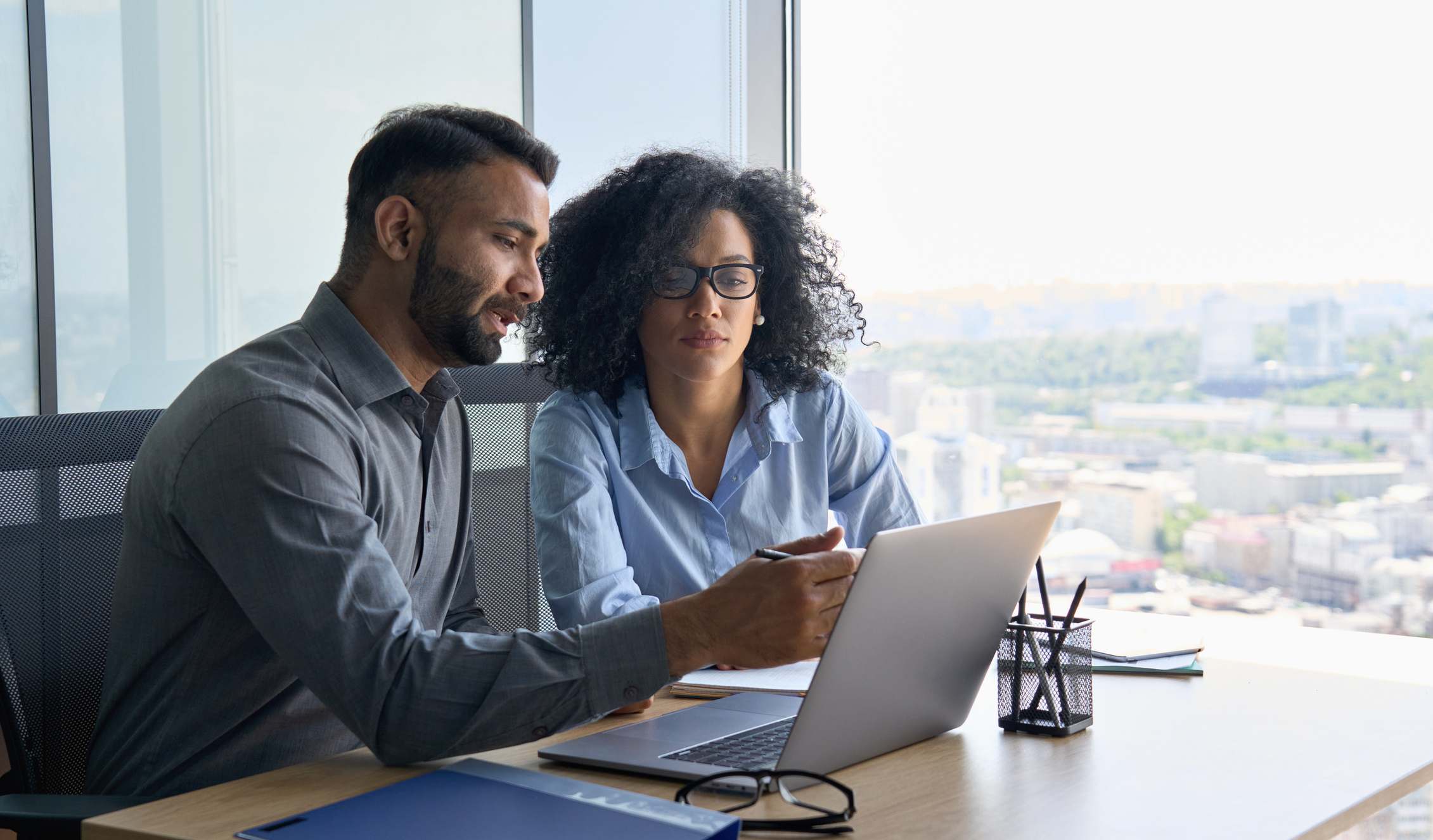 Multiethnic-colleagues-sitting-at-desk-looking-at-laptop-computer-in-office-what-is-my-earning-potential