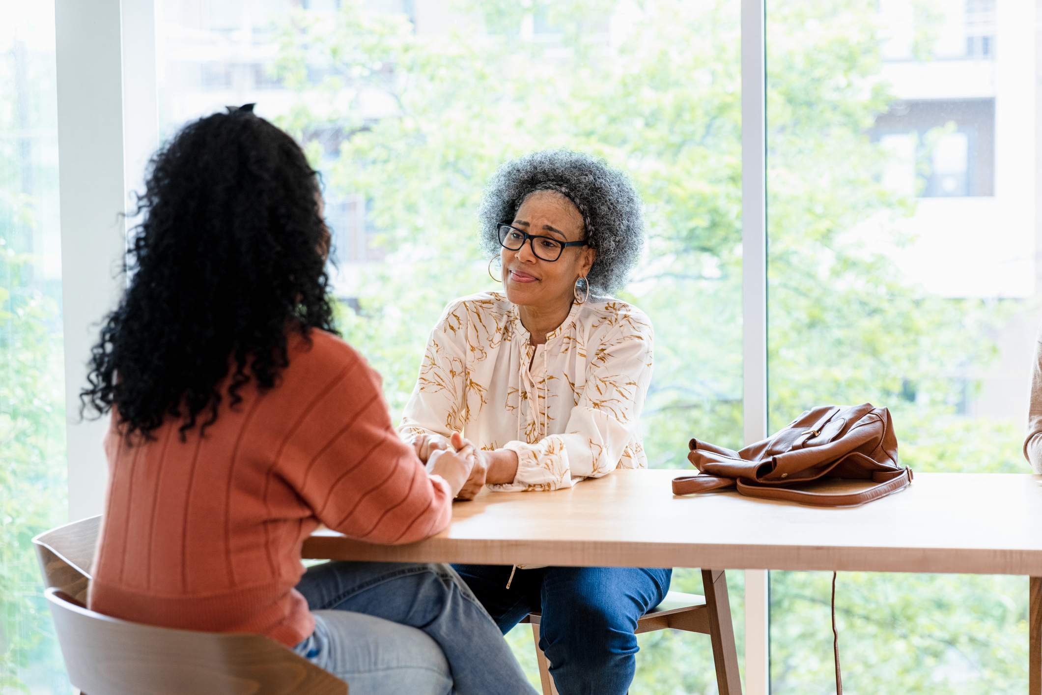 Older-woman-holding-young-womans-hand-with-empathy-employee-strengths