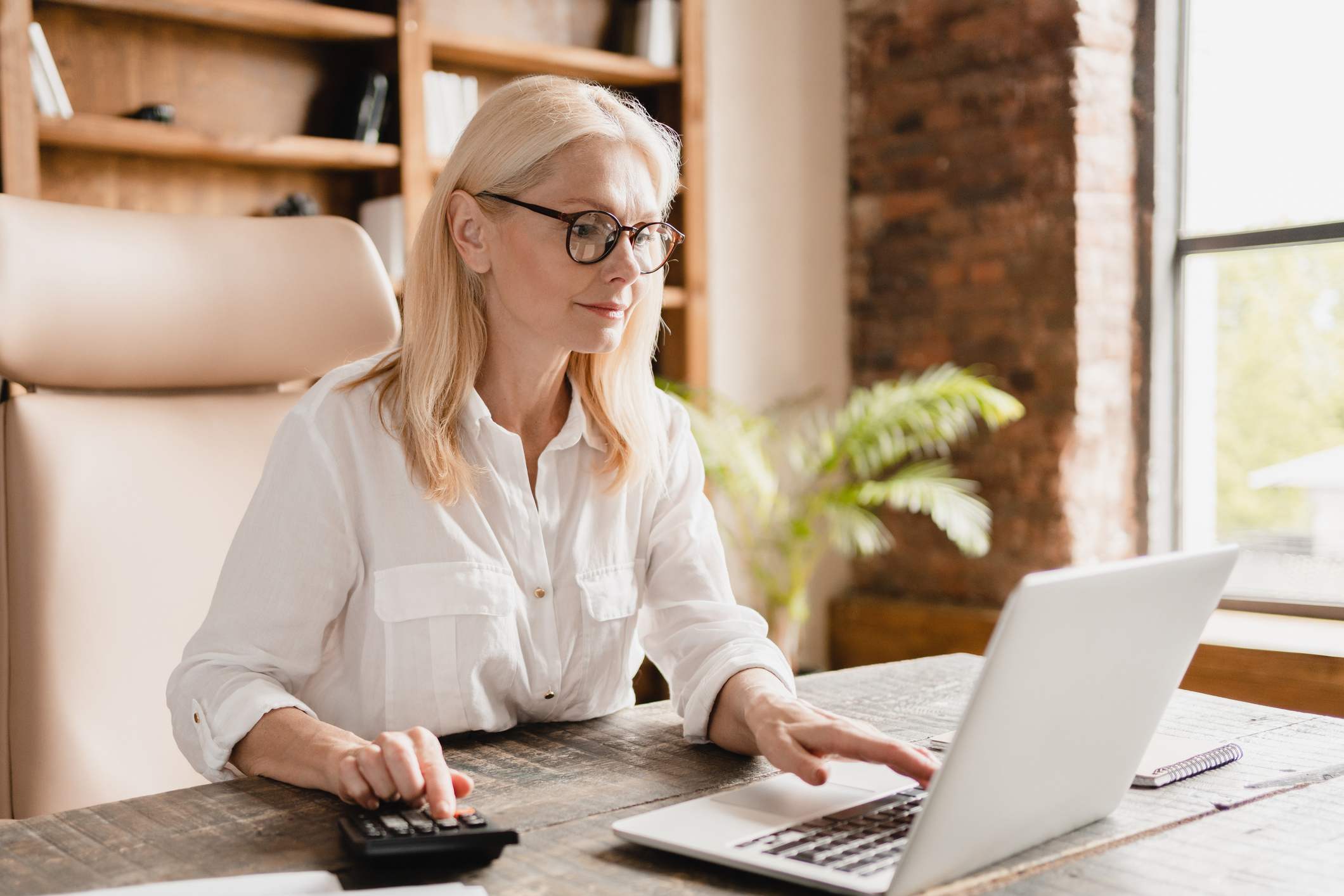 Older-woman-using-calculator-and-laptop-employee-value-proposition