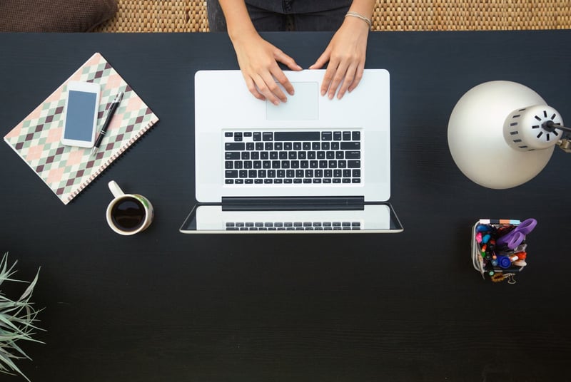 Overhead-shot-of-woman-working-on-laptop-at-home