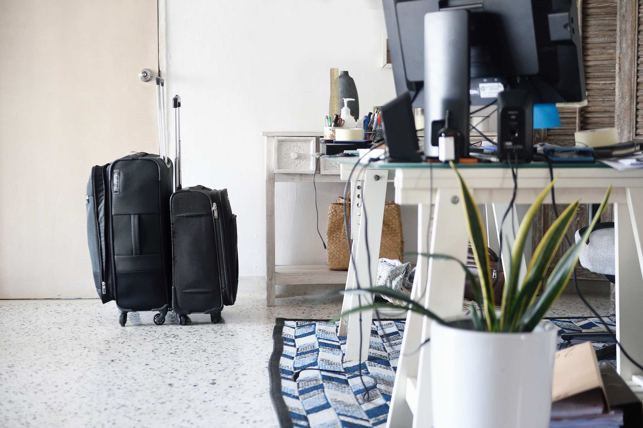 Packed-suitcases-by-a-home-office-stress-leave-from-work