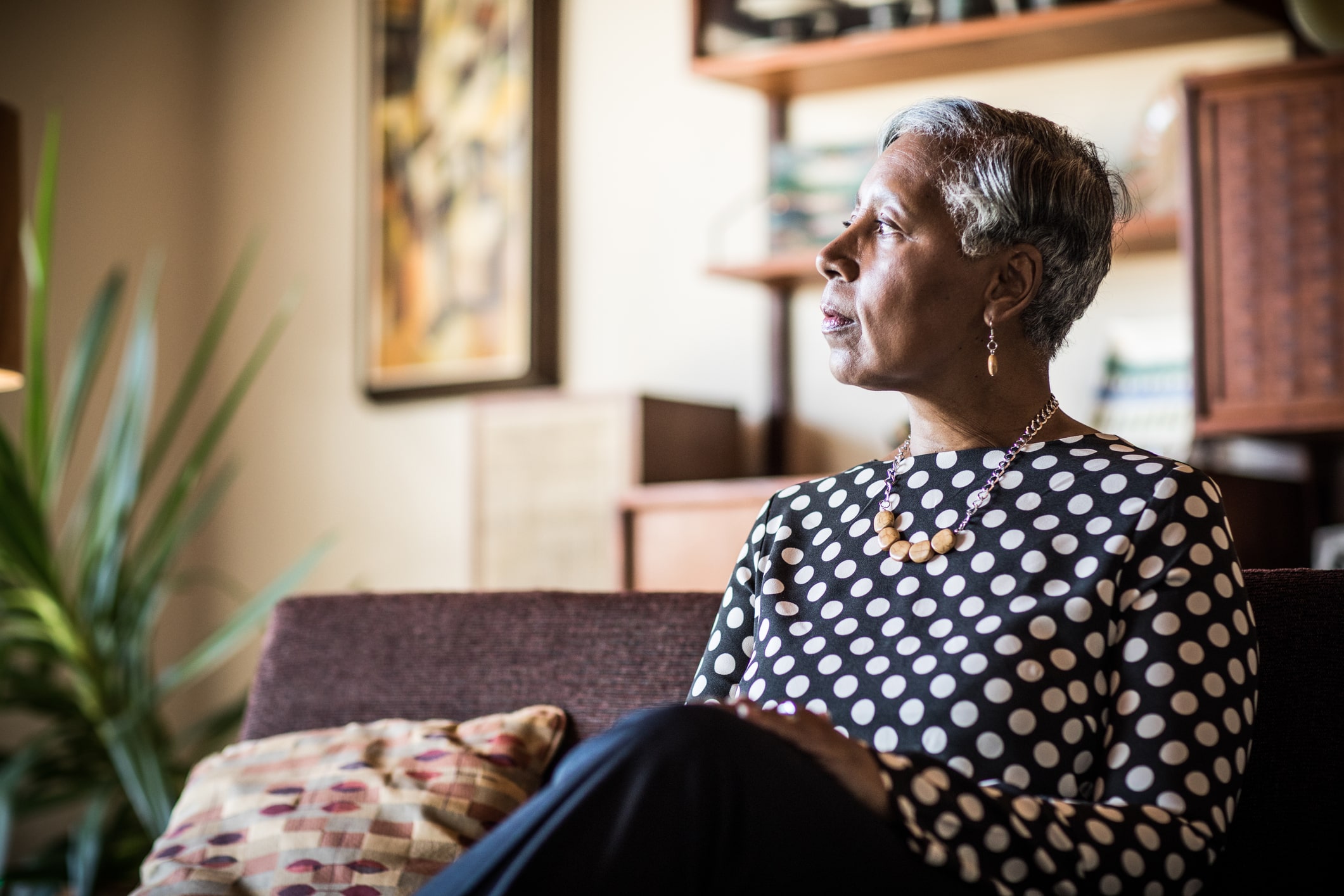 Portrait-of-woman-sitting-on-couch-at-home-what-are-stressors