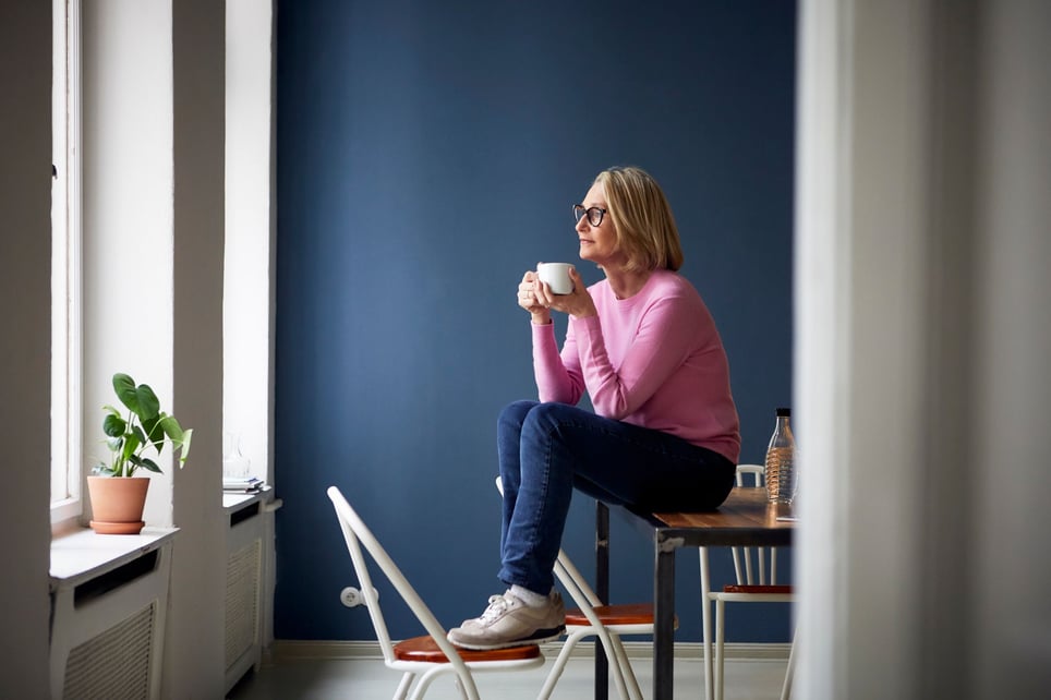 Relaxed-woman-with-a-cup-of-coffee-by-herself-looking-out-the-window-how-to-be-alone-with-my-thoughts