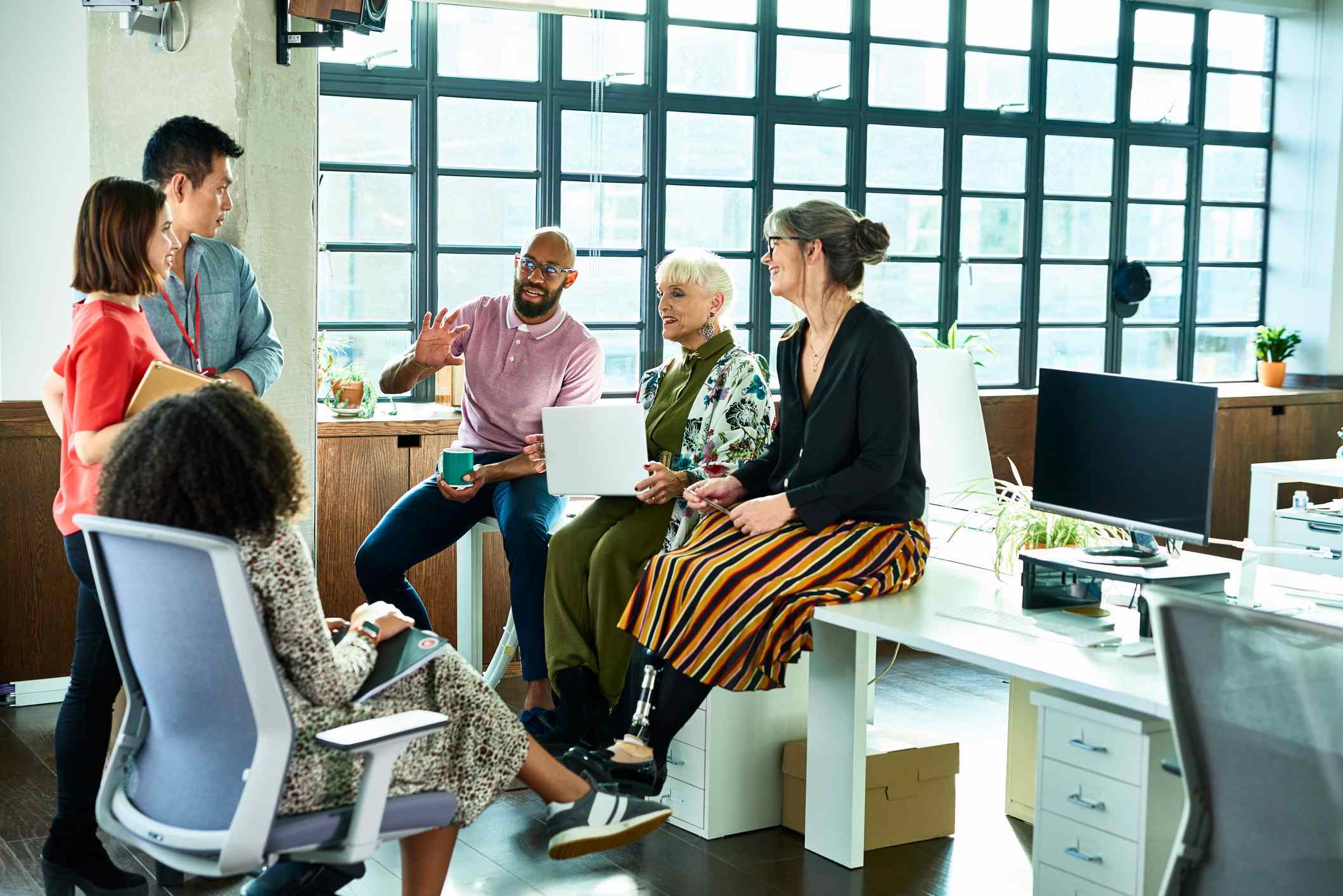 Relaxed-work-team-discussing-something-at-office-breaking-down-silos