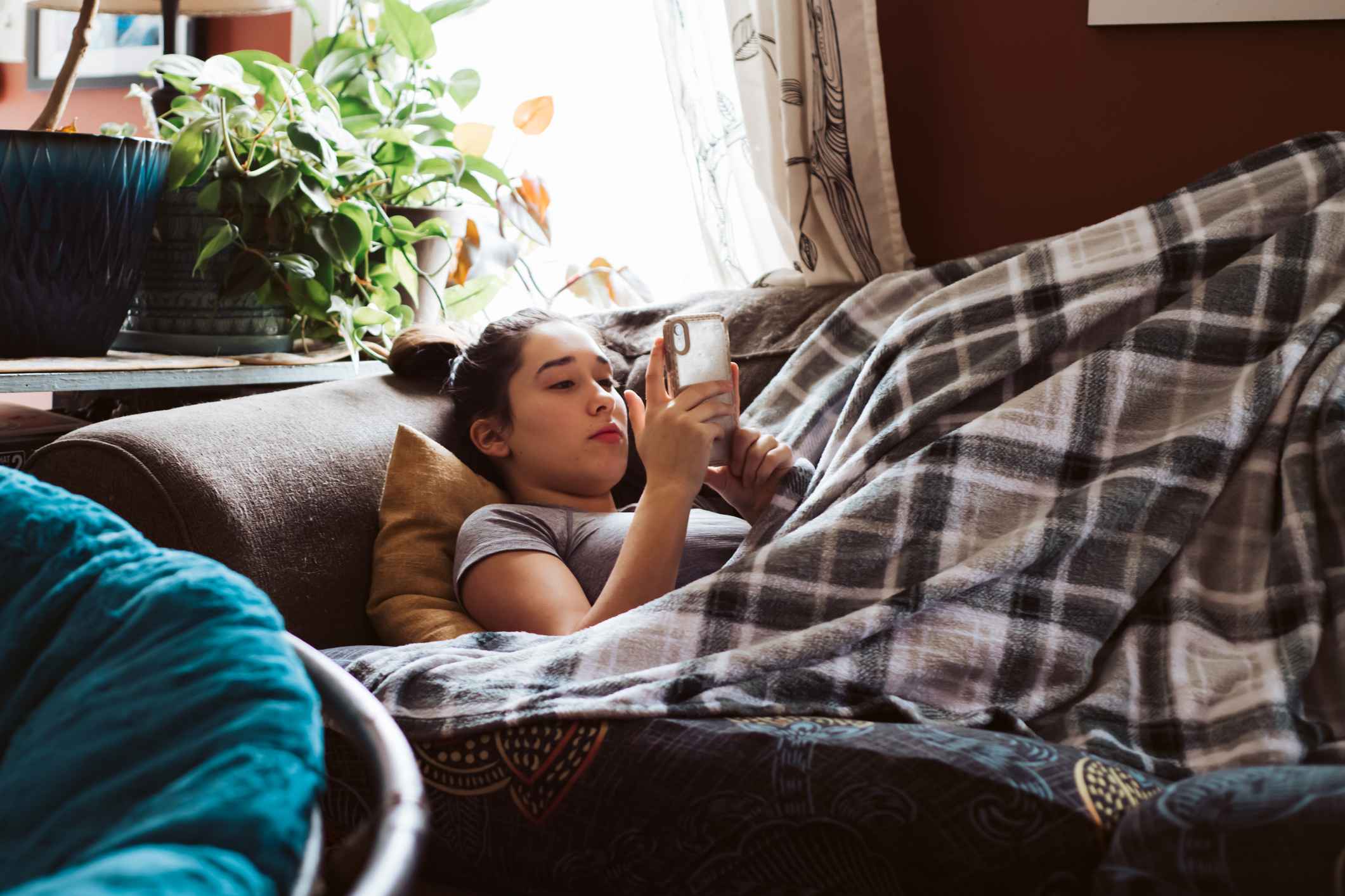 Sad-young-woman-alone-on-her-couch-using-her-phone-employee-health