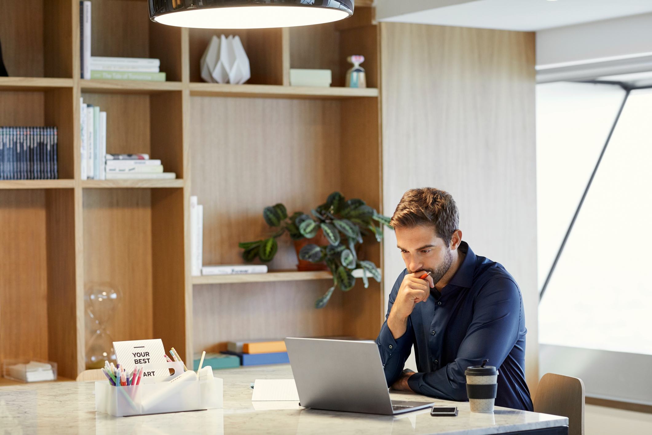 Serious-businessman-using-laptop-at-office-desk-good-reason-to-leave-work