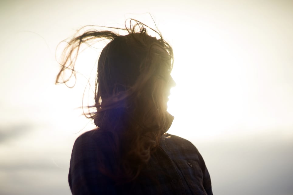 Silhouette-of-woman-with-hair-blowing-in-the-wind-factors-that-promote-resilience