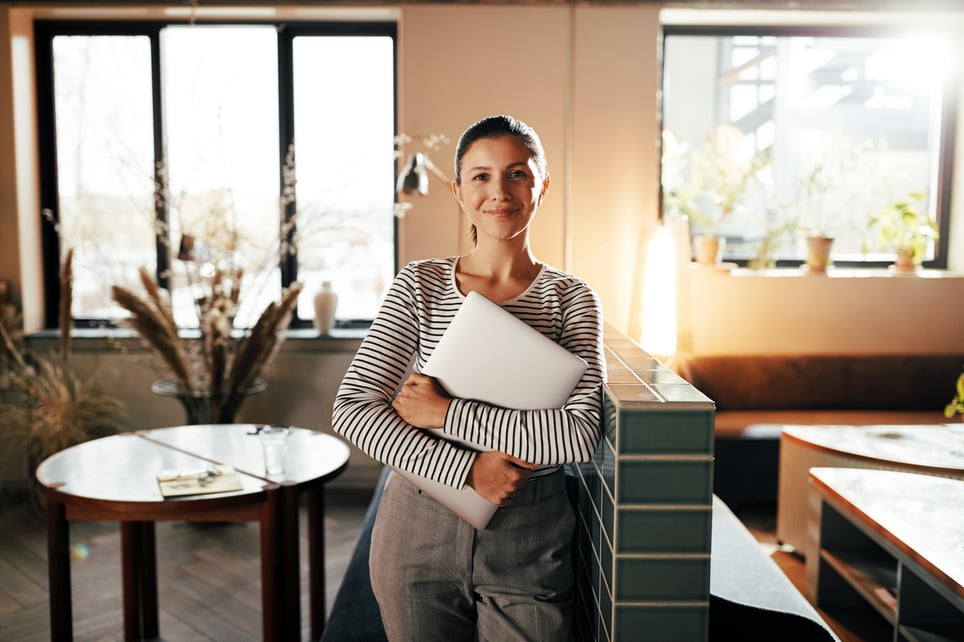 Smiling-Businesswoman-Standing-With-A-Laptop-be-your-own-boss