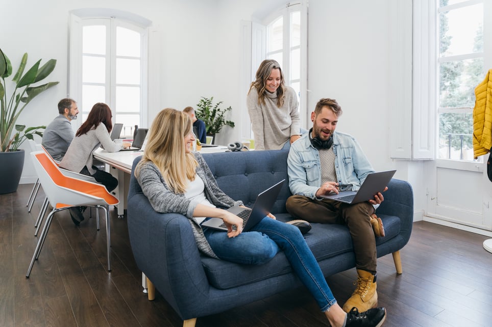 Smiling-Coworkers-Chatting-On-Couch-Office-how-to-make-friends-at-work