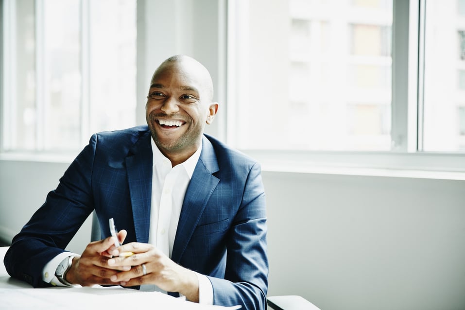 Smiling-businessman-in-discussion-at-workstation-self-motivation-examples