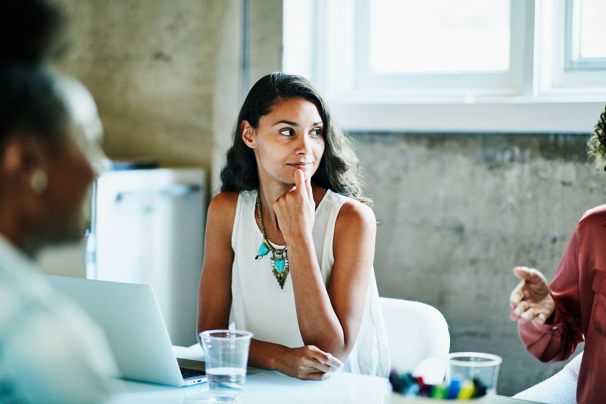 Smiling-businesswoman-listening-to-coworker-during-meeting-good-reason-to-leave-work