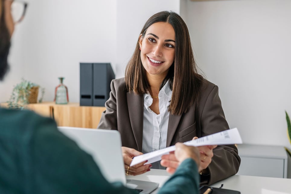 Smiling-woman-at-job-interview-reviewing-document-part-time-employee-benefits