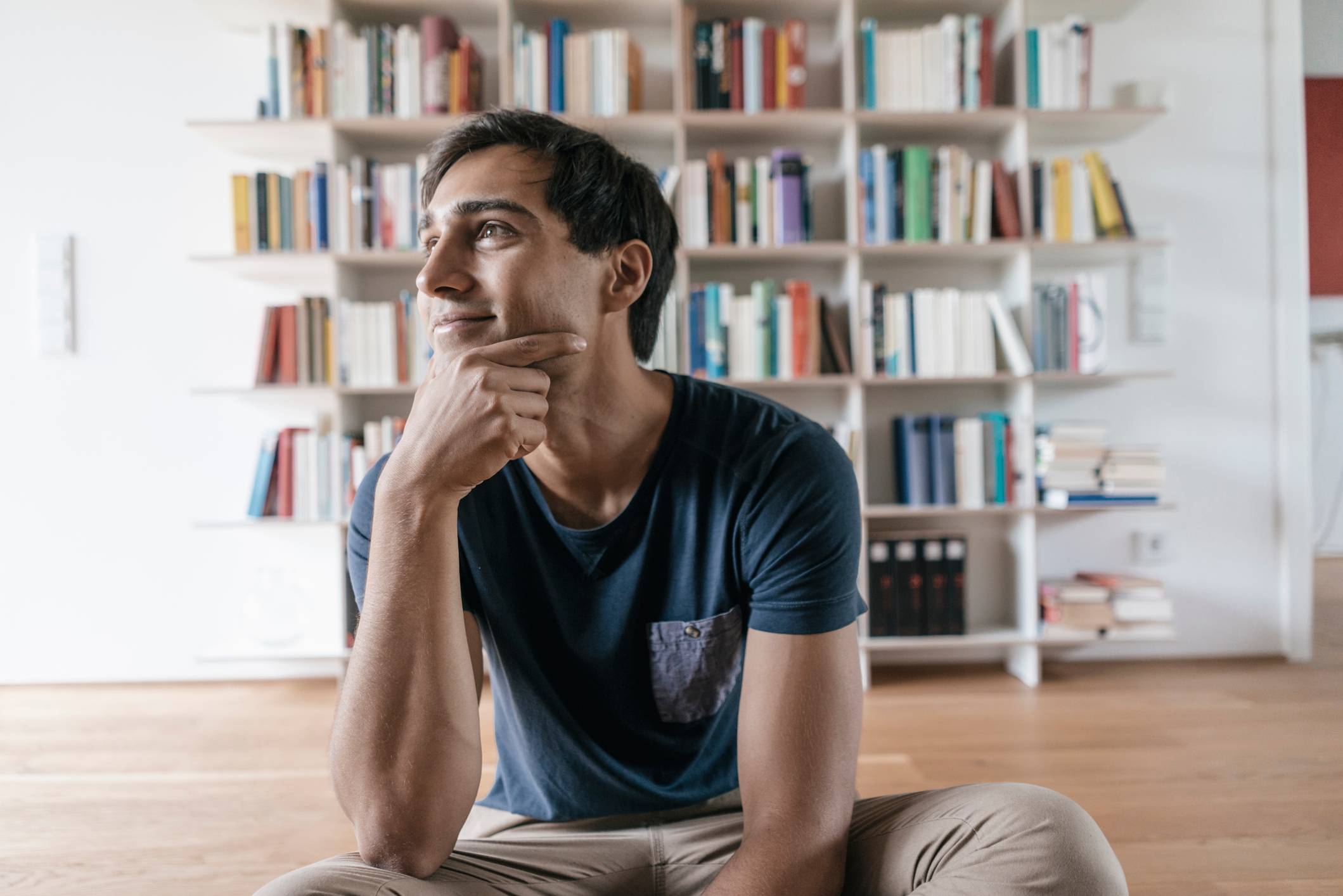 Smiling-young-man-at-home-looking-sideways-how-to-write-a-letter-of-recommendation