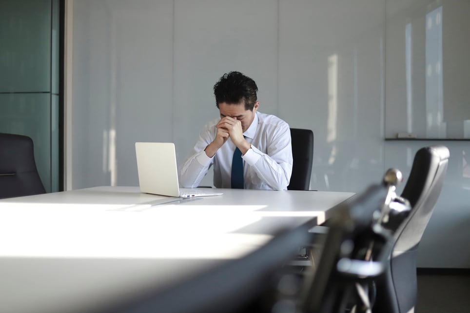 Stressed-man-sitting-in-office-chair-alone-absenteeism