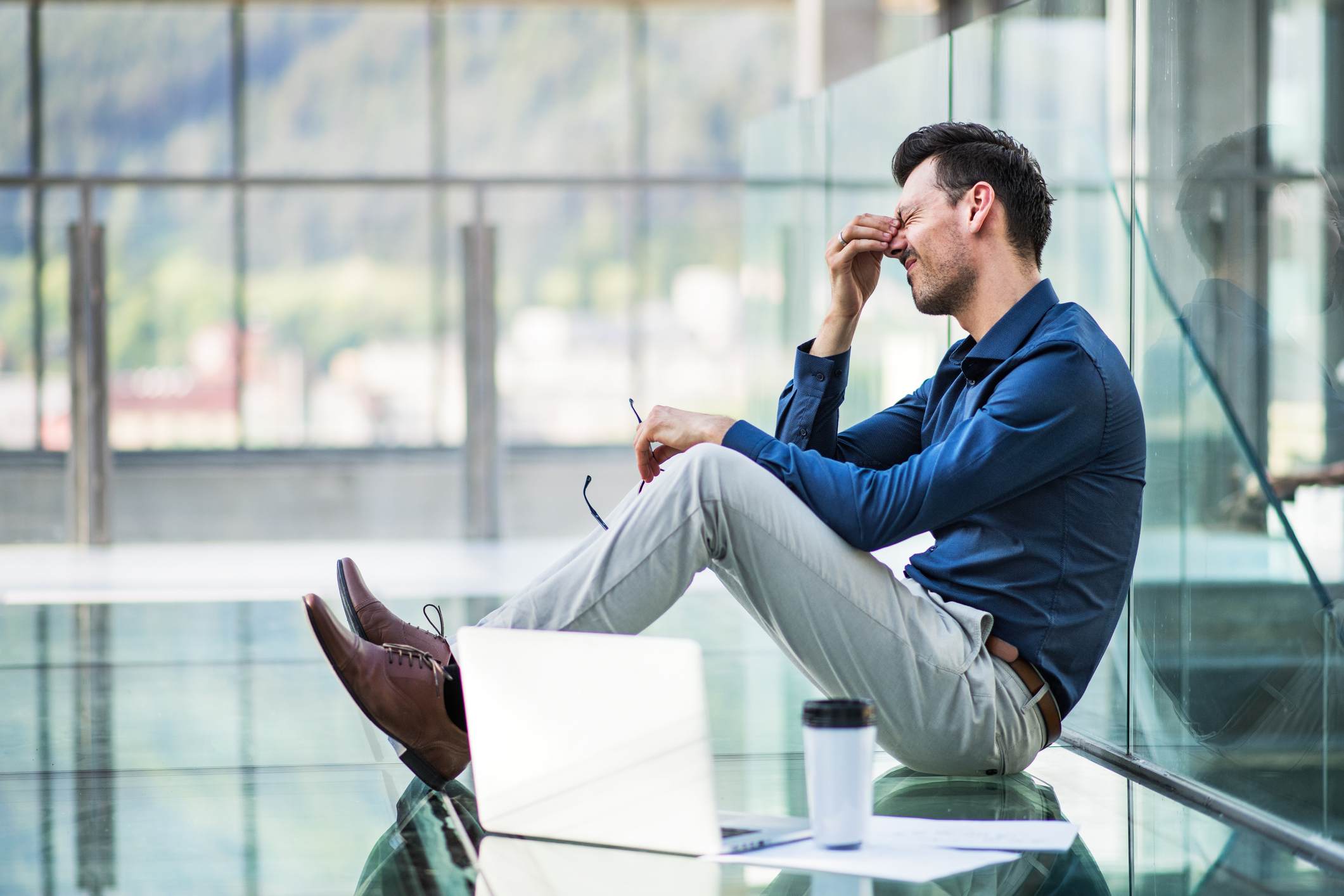 Stressed-man-sitting-on-office-floor-absenteeism