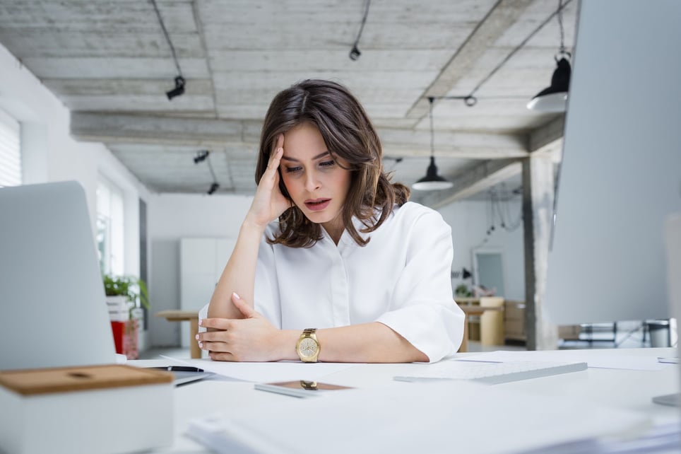 Stressed-woman-covering-her-face-at-work-worried-about-getting-fired