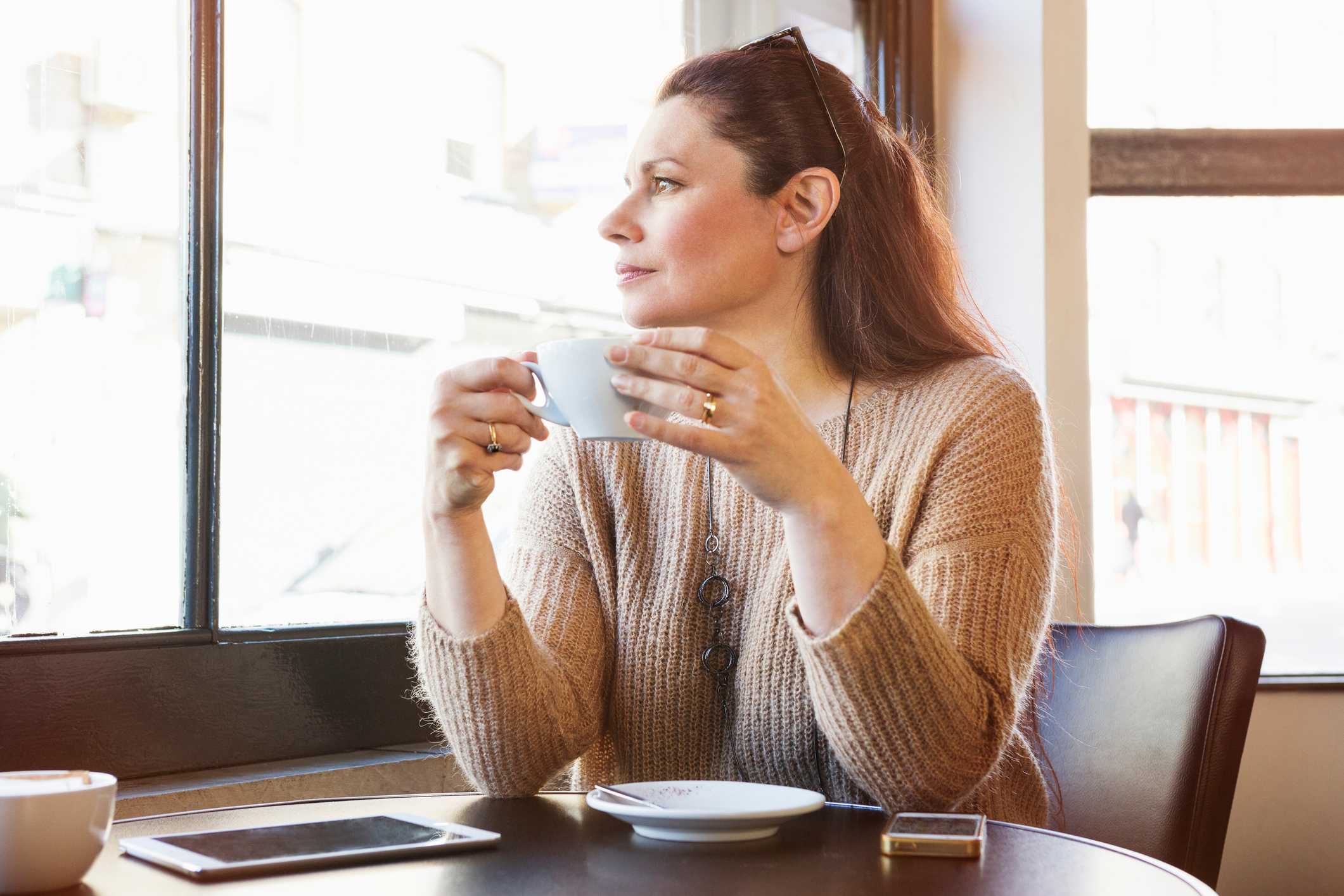 Thoughtful-woman-looking-outside-window-with-coffee-how-to-stop-self-pity