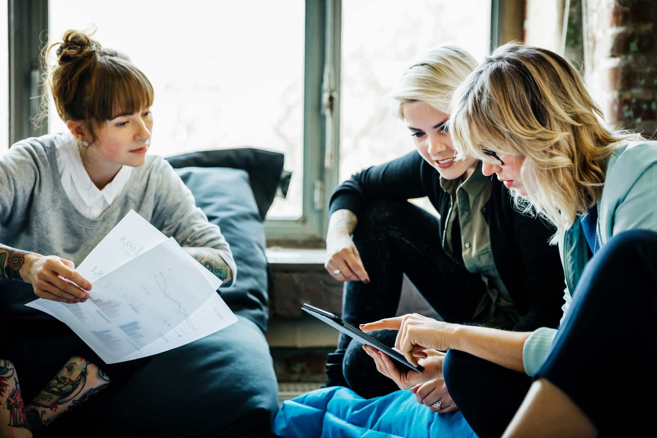 Three-collegues-looking-at-tablet-and-discussing-something-together-upward-communication