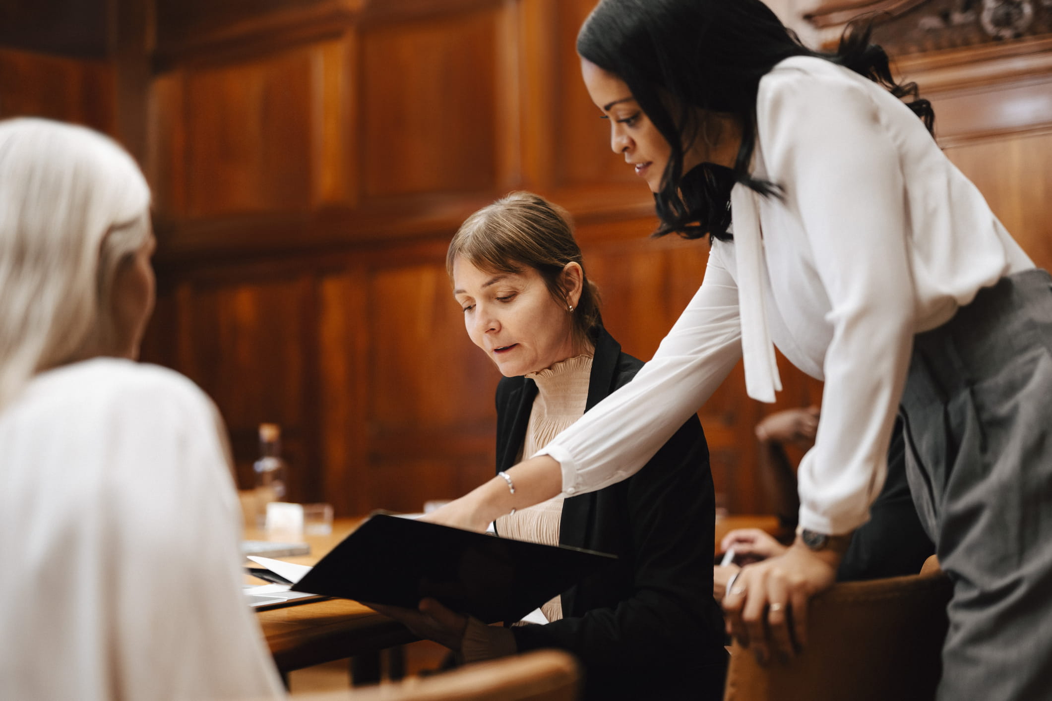 Three-women-discussing-the-legal-terms-of-a-contract-employee-poaching