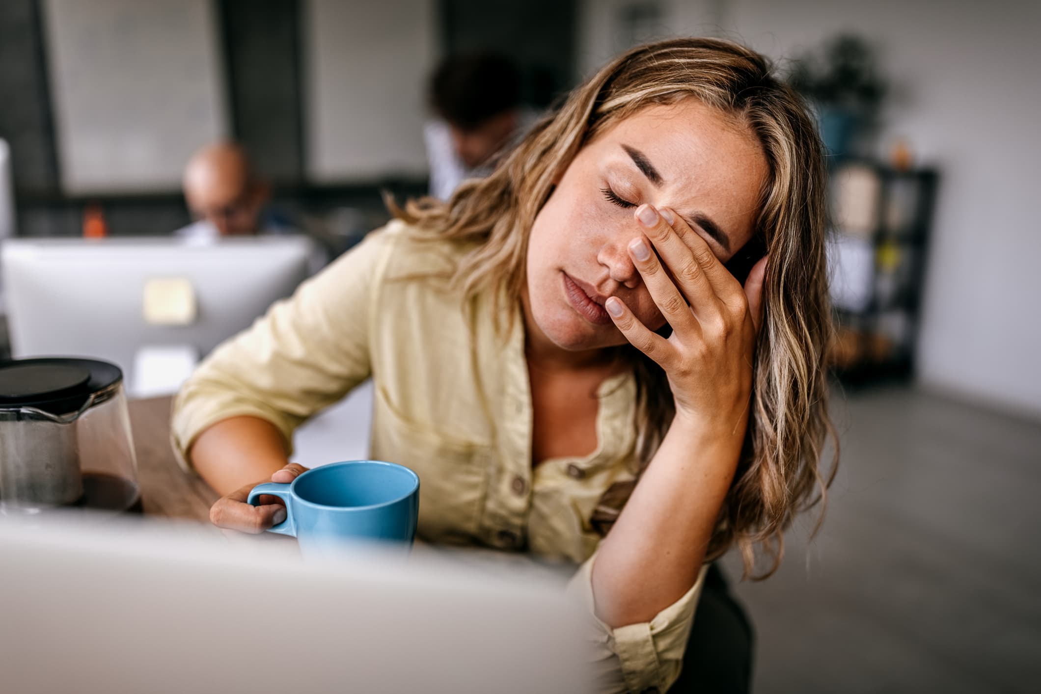 Tired-business-woman-rubbing-eyes-at-office-what-is-willpower