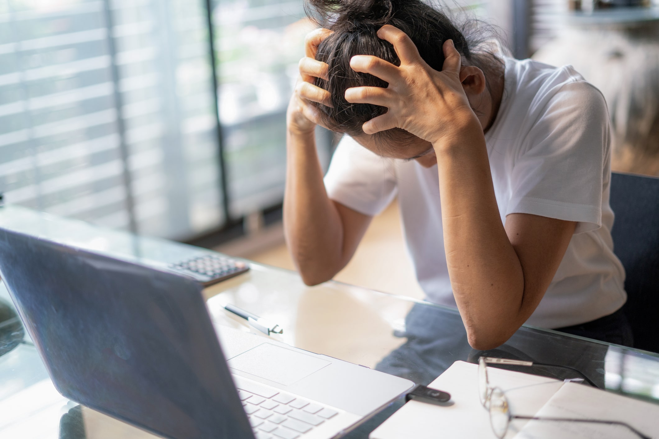 Tired-young-business-woman-with-a-headache-using-laptop-exercise-and-mental-health