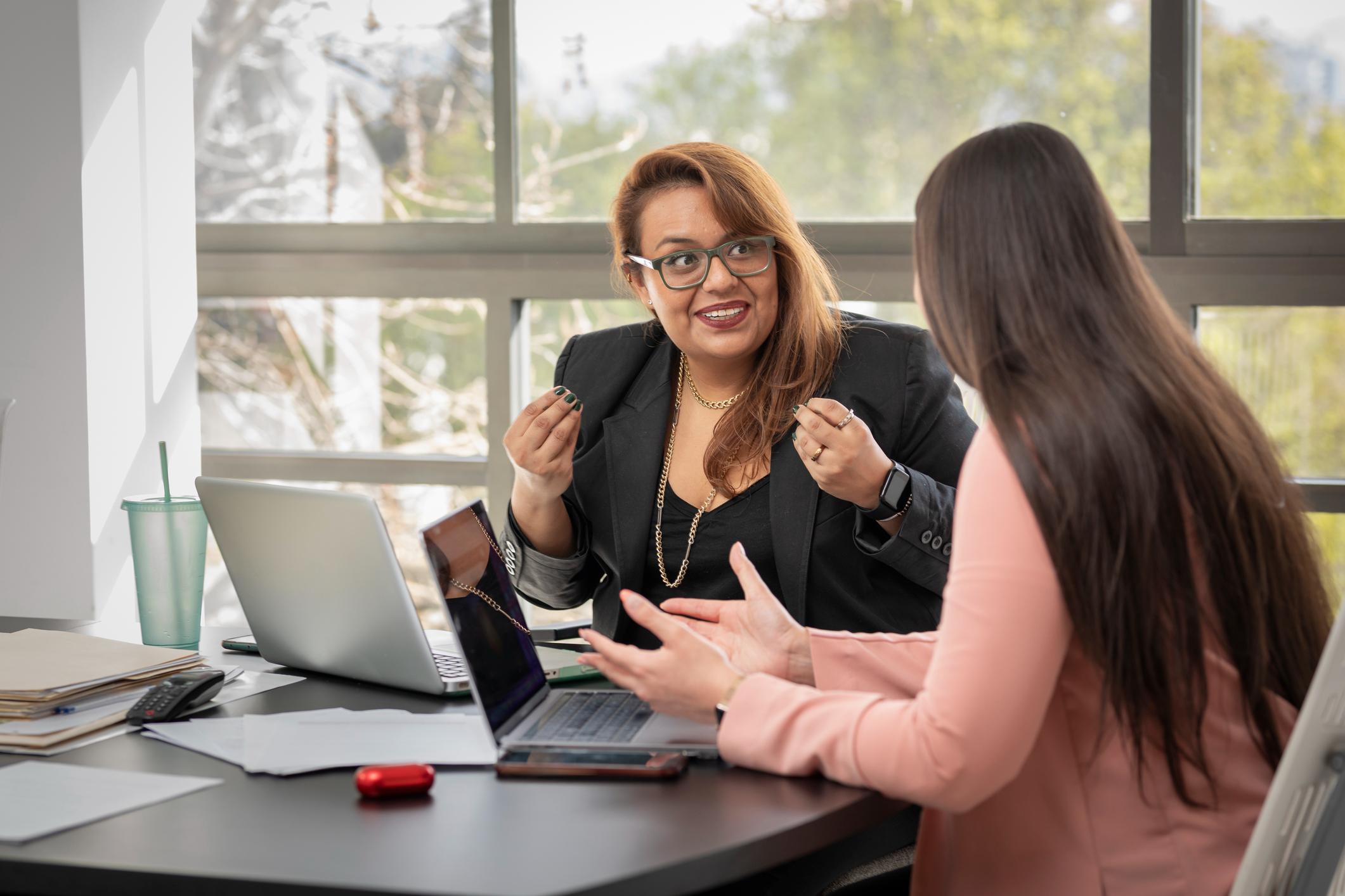 Two-Latina-women-chat-happily-as-they-work-why-are-you-leaving-your-current-job