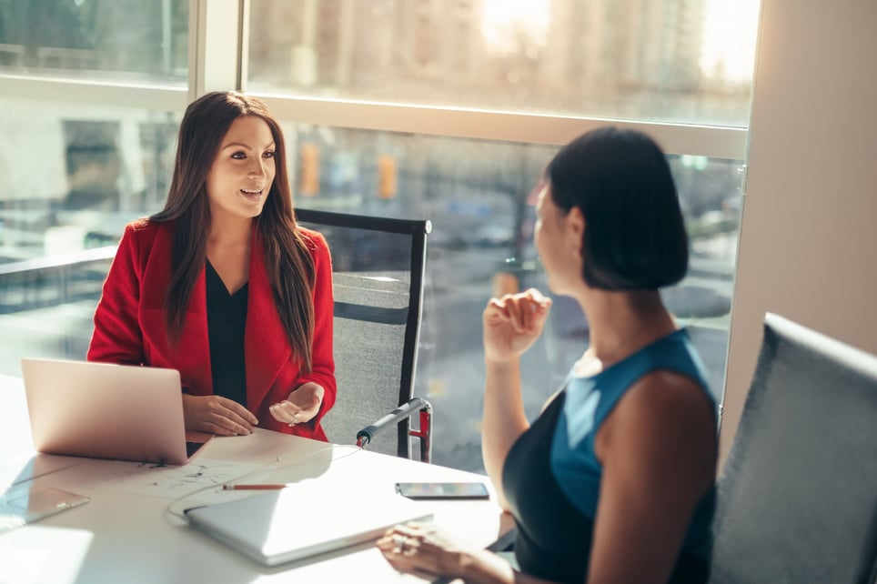 Two-business-women-colleagues-discussing-why-are-you-interested-in-this-position