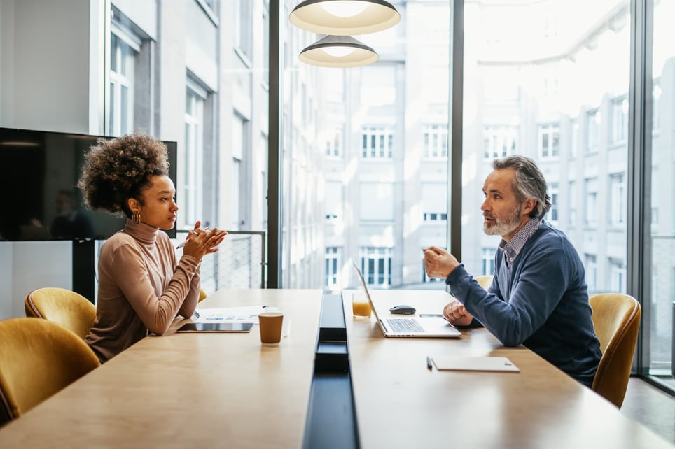 Two-coworkers-in-a-meeting-how-to-manage-two-jobs-at-once