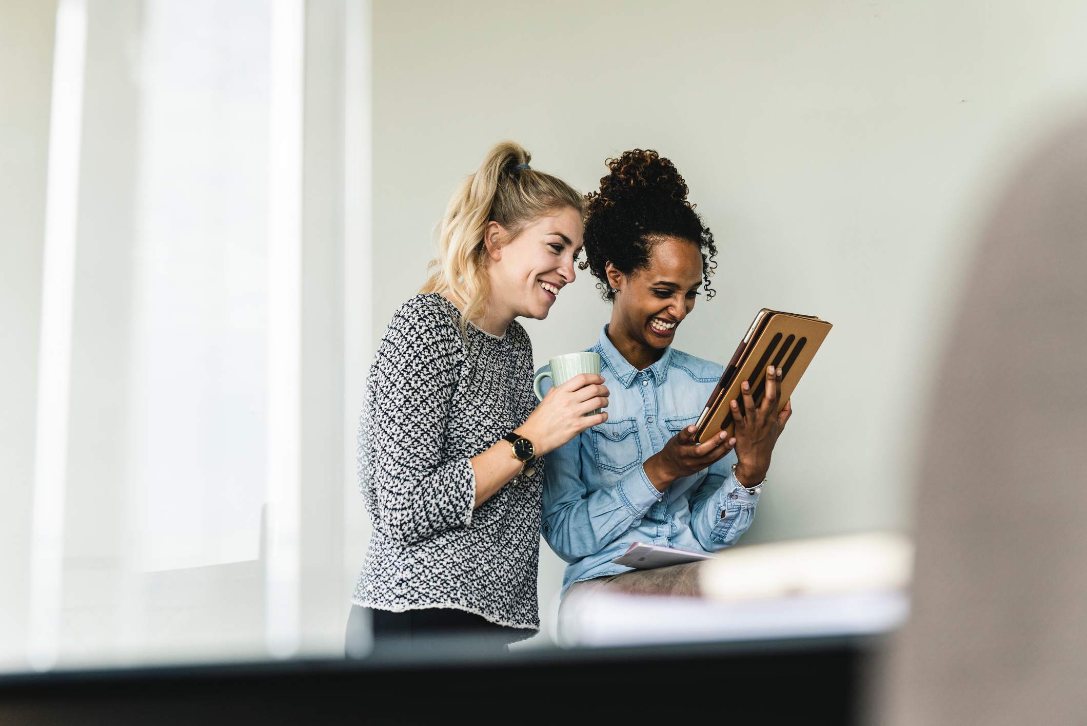 Two-female-coworkers-gossiping-and-laughing-how-to-know-if-im-oversharing