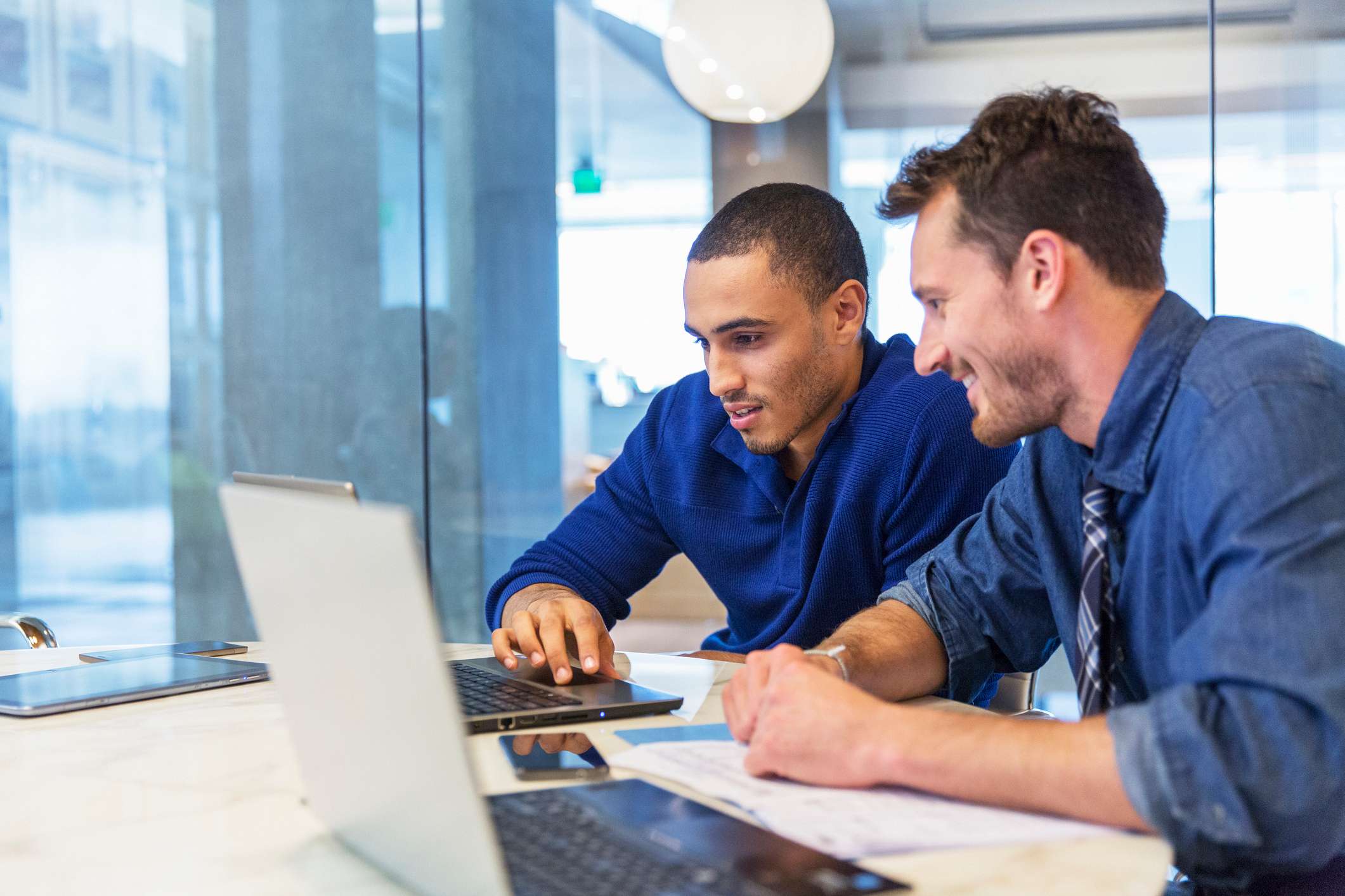 Two-man-coworkers-looking-at-laptop-together-team-collaboration