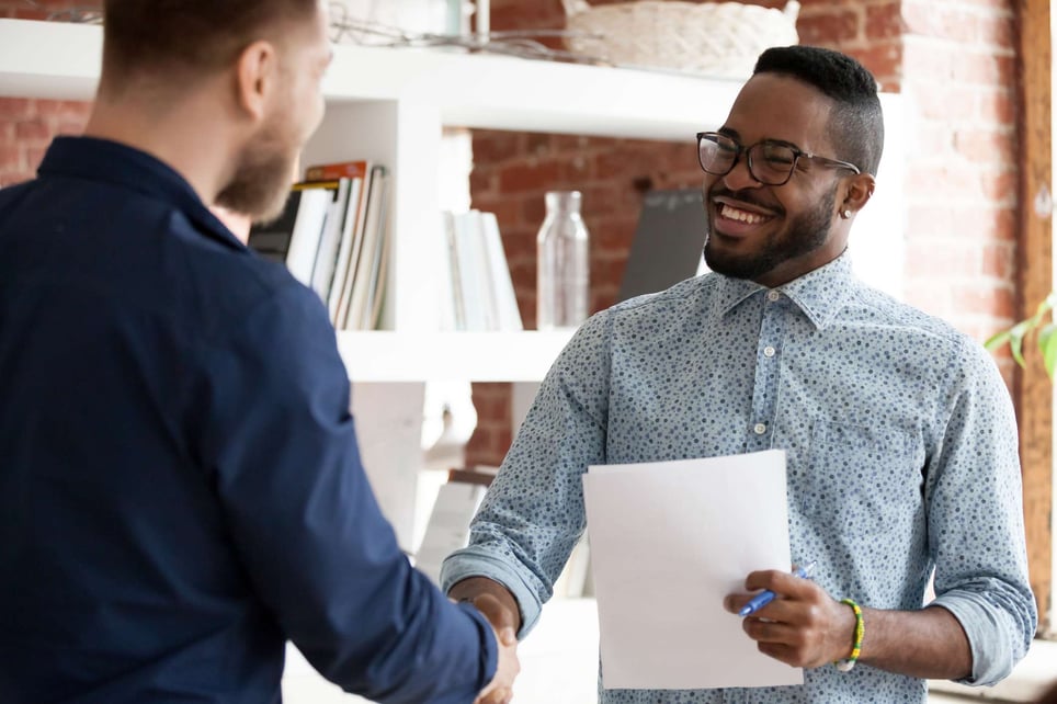 Two-men-giving-handshake-and-smiling-at-interview-how-to-write-a-linkedin-summary