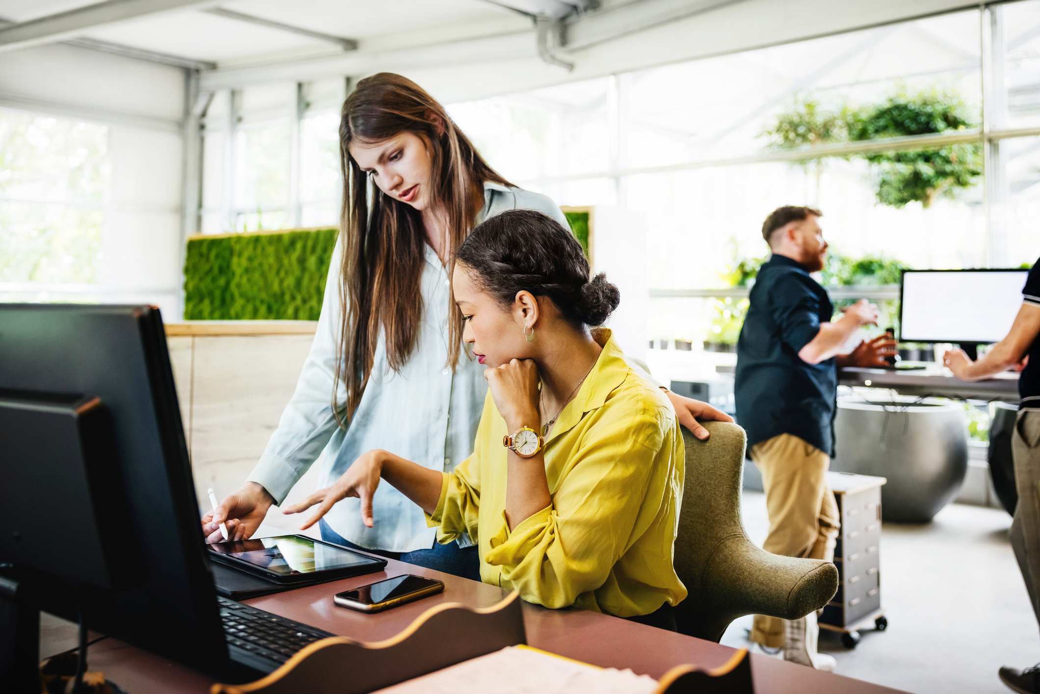 Two-women-collegues-looking-at-files-together-in-tablet-jobs-you-can-get-with-an-economics-degree