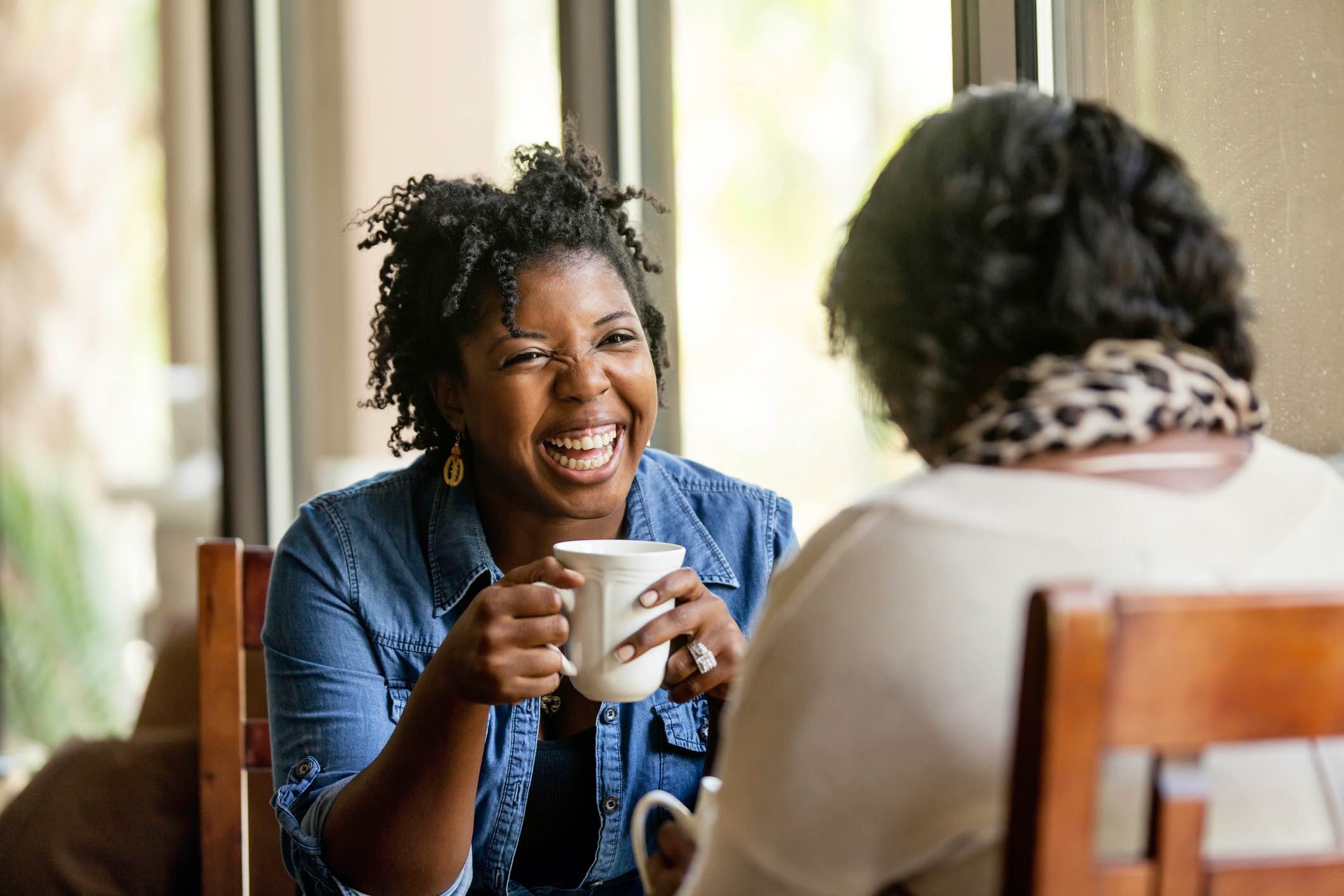 Two-women-having-a-happy-conversation-at-a-cafe-positive-personality-traits