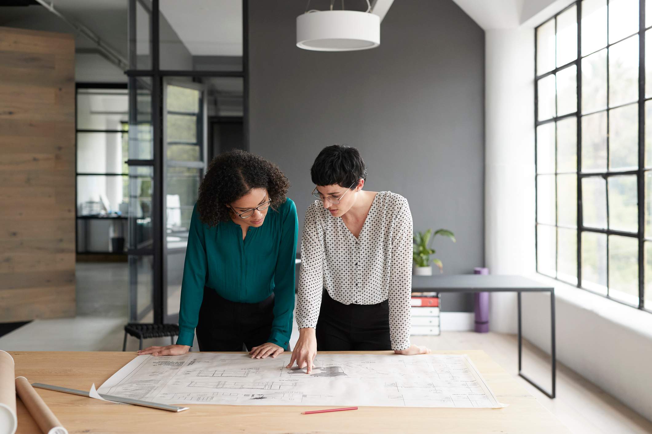 Two-women-reviewing-project-at-office-how-to-write-a-linkedin-summary