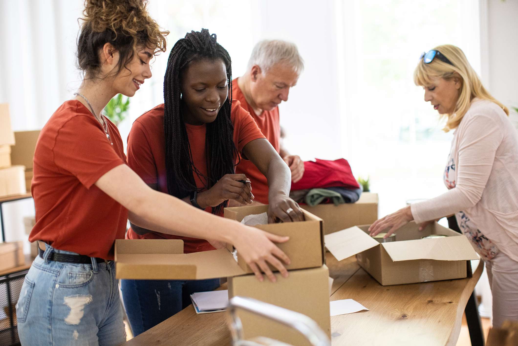 Two-women-with-uniform-filling-up-boxes-at-volunteer-center-how-far-back-should-a-resume-go