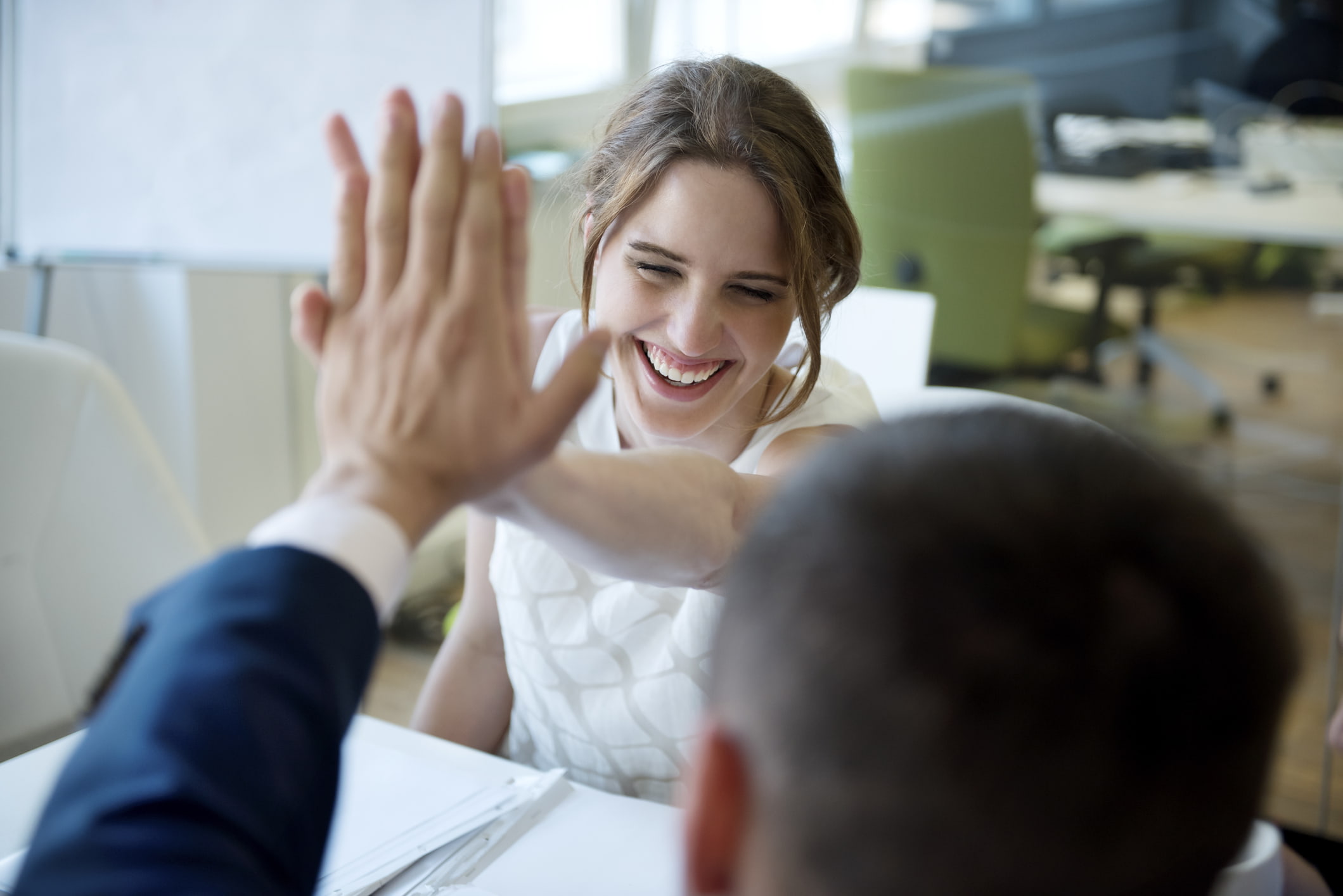 Two-young-coworkers-high-fiving-tacit-knowledge