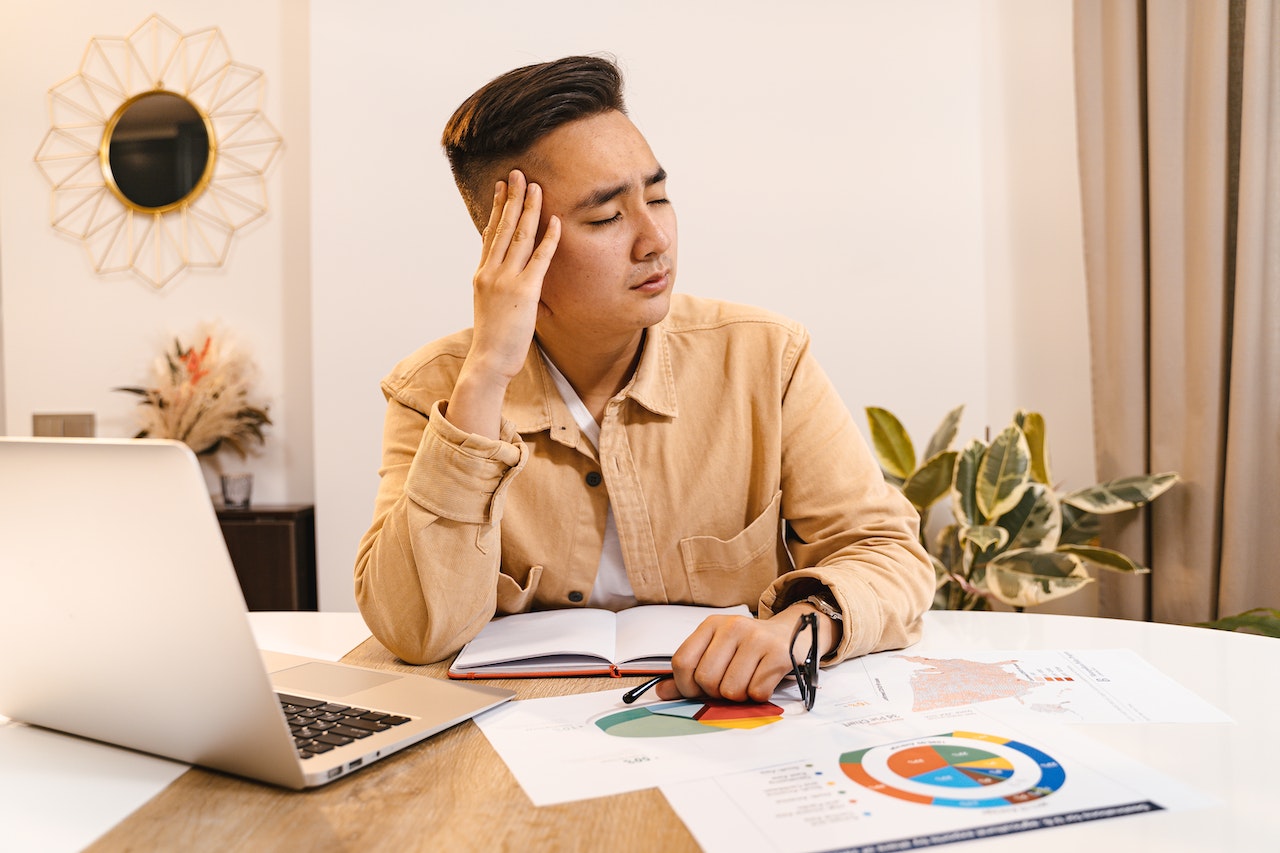 Upset-man-with-eyes-closed-while-working-from-home-sibling-comparison