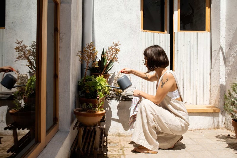 Woman-Watering-Plants-At-Home