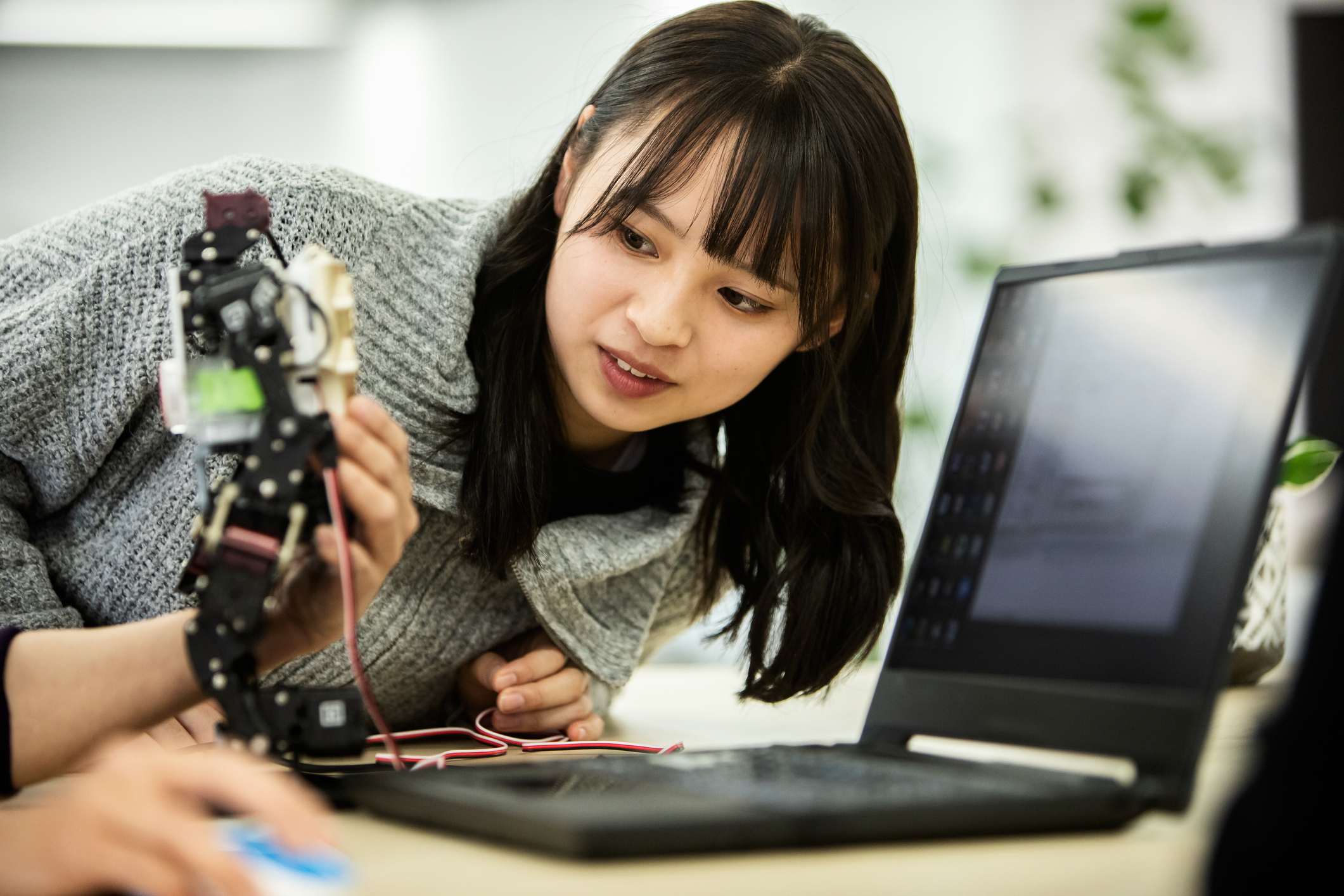 Woman-at-office-looking-at-mini-robot-what-is-disruptive-innovation