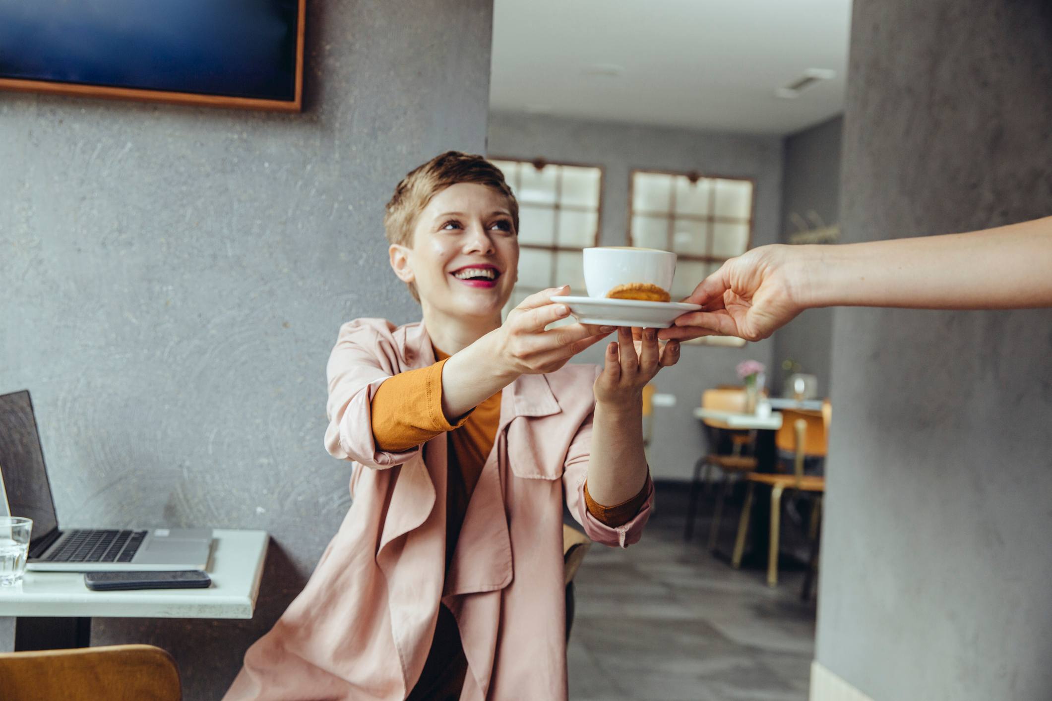 Woman-at-restaurant-with-laptop-getting-a-cup-of-coffee-how-to-adjust-to-night-shifts